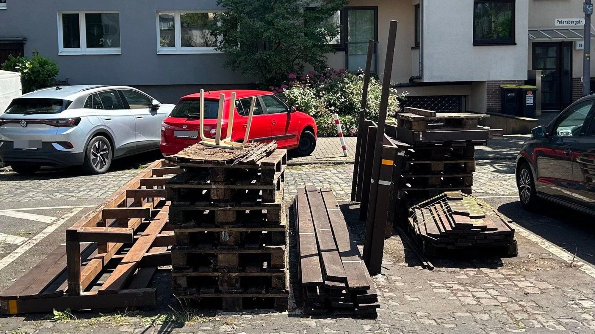 Auf einem Parkplatz stehen Holz-Elemente.