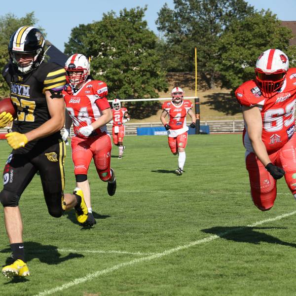 Fynn Handschke läuft, mit dem Football unter dem Arm, den Gegenspielern davon.