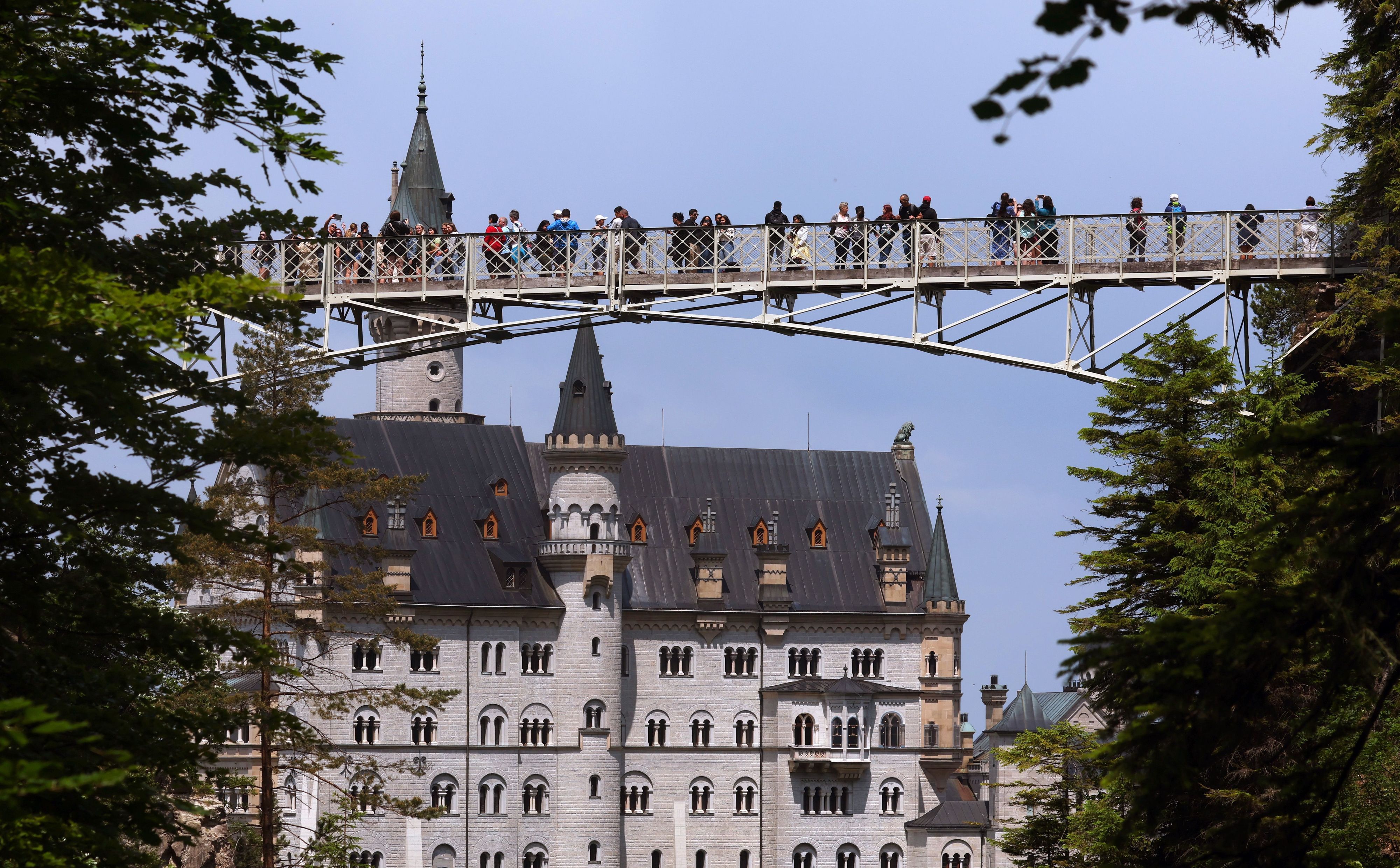 Touristen stehen auf der Marienbrücke vor dem Schloss Neuschwanstein. (Archivbild)