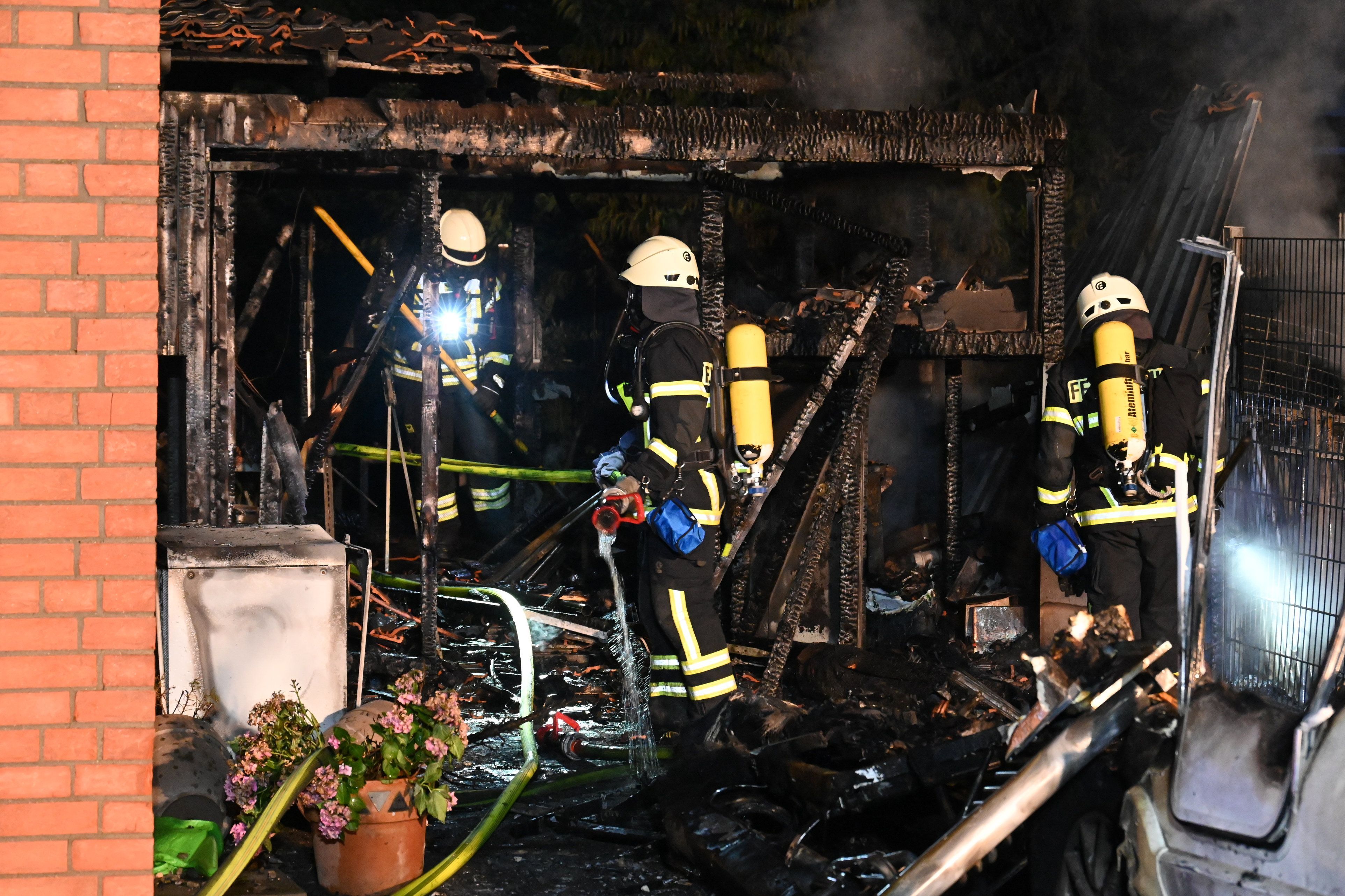Feuerwehrleute löschen einen Schuppen. Alles ist verkohlt.