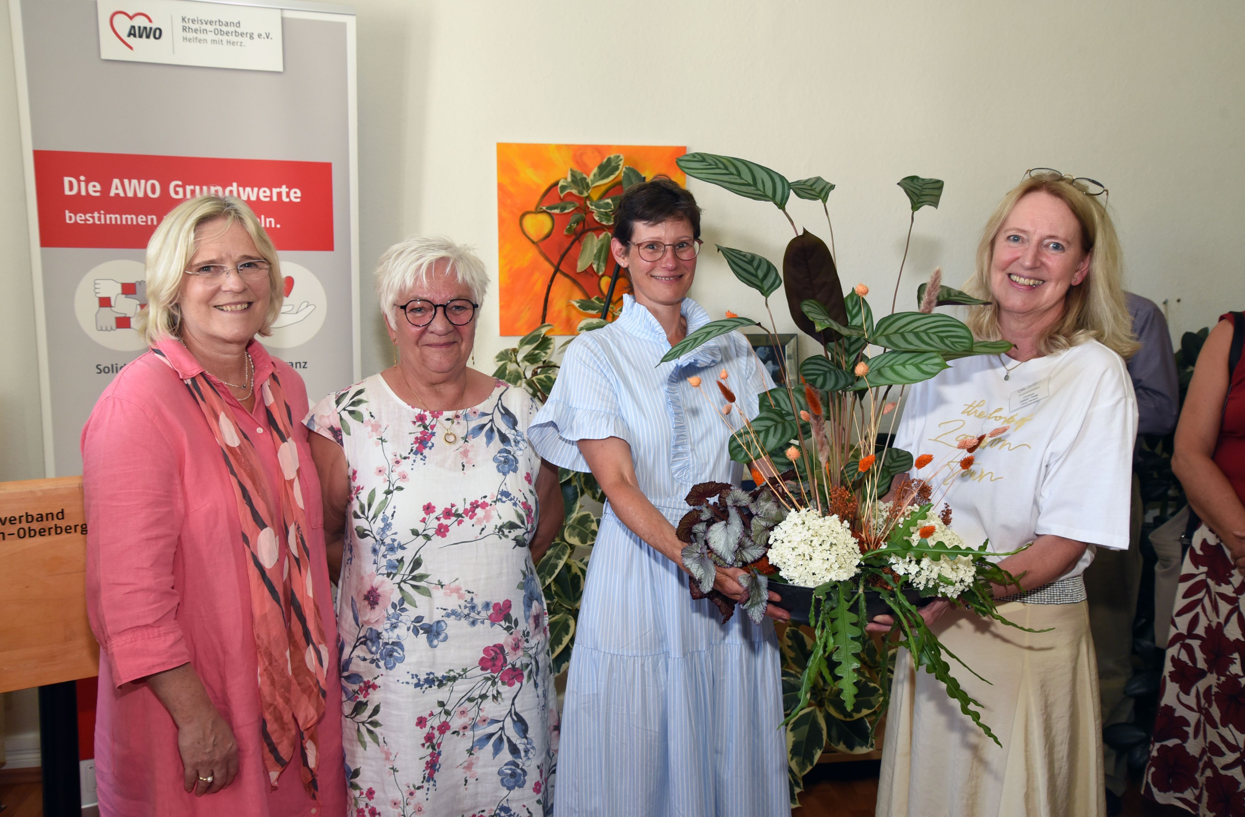 Vier Frauen und ein Blumenstrauß.