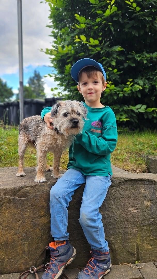 Bruno sitzt neben einem kleinen Hund.