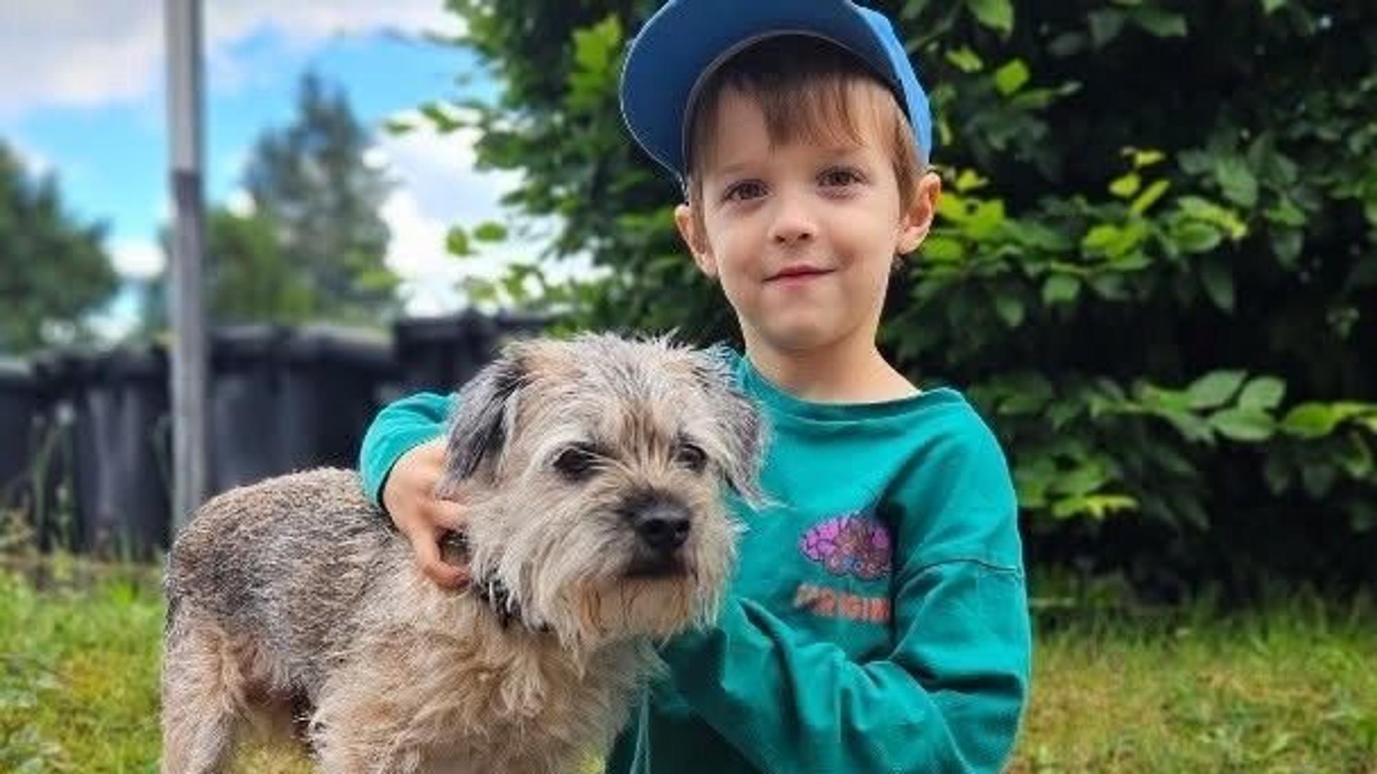 Bruno sitzt neben einem kleinen Hund.