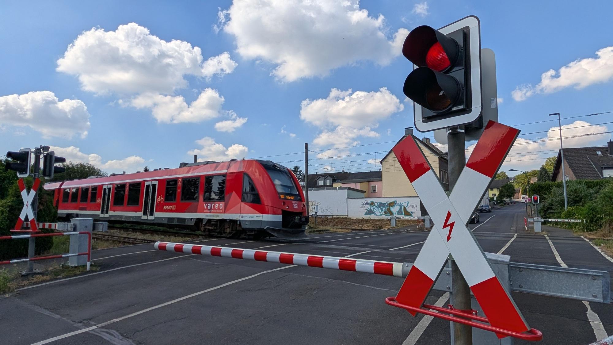 Eine Regionalbahn passiert den Bahnübergang an der Schmittenstraße in Hürth-Fischenich.