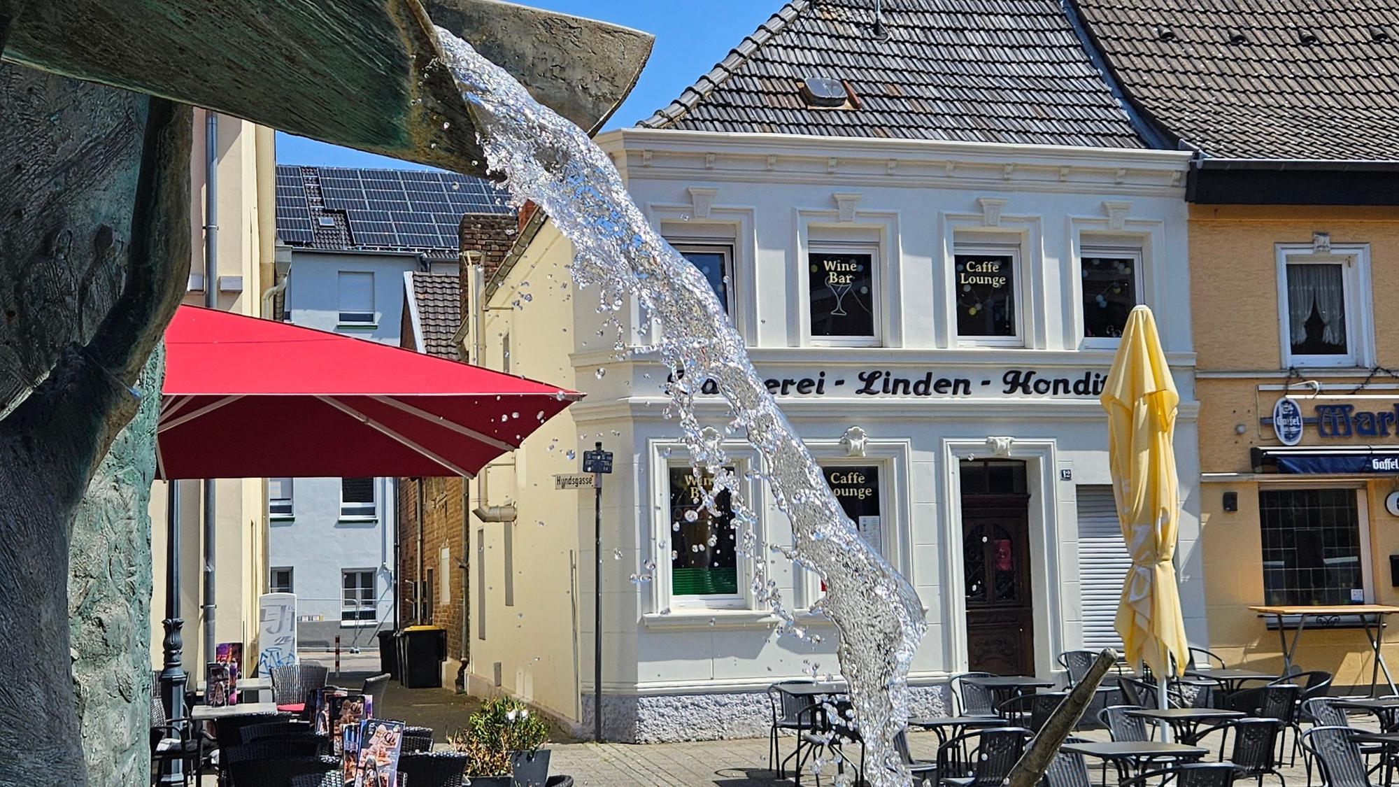 Zu sehen ist ein Brunnen auf dem Bedburger Marktplatz.