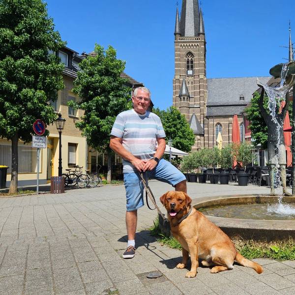 Zu sehen sind Wolfgang Esser und sein Hund auf dem Bedburger Marktplatz.