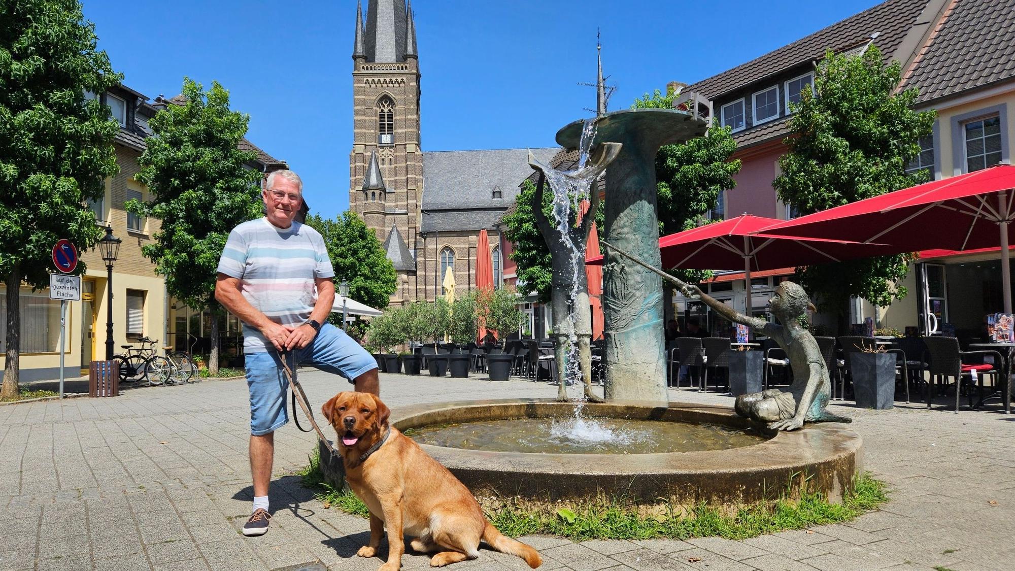 Zu sehen sind Wolfgang Esser und sein Hund auf dem Bedburger Marktplatz.
