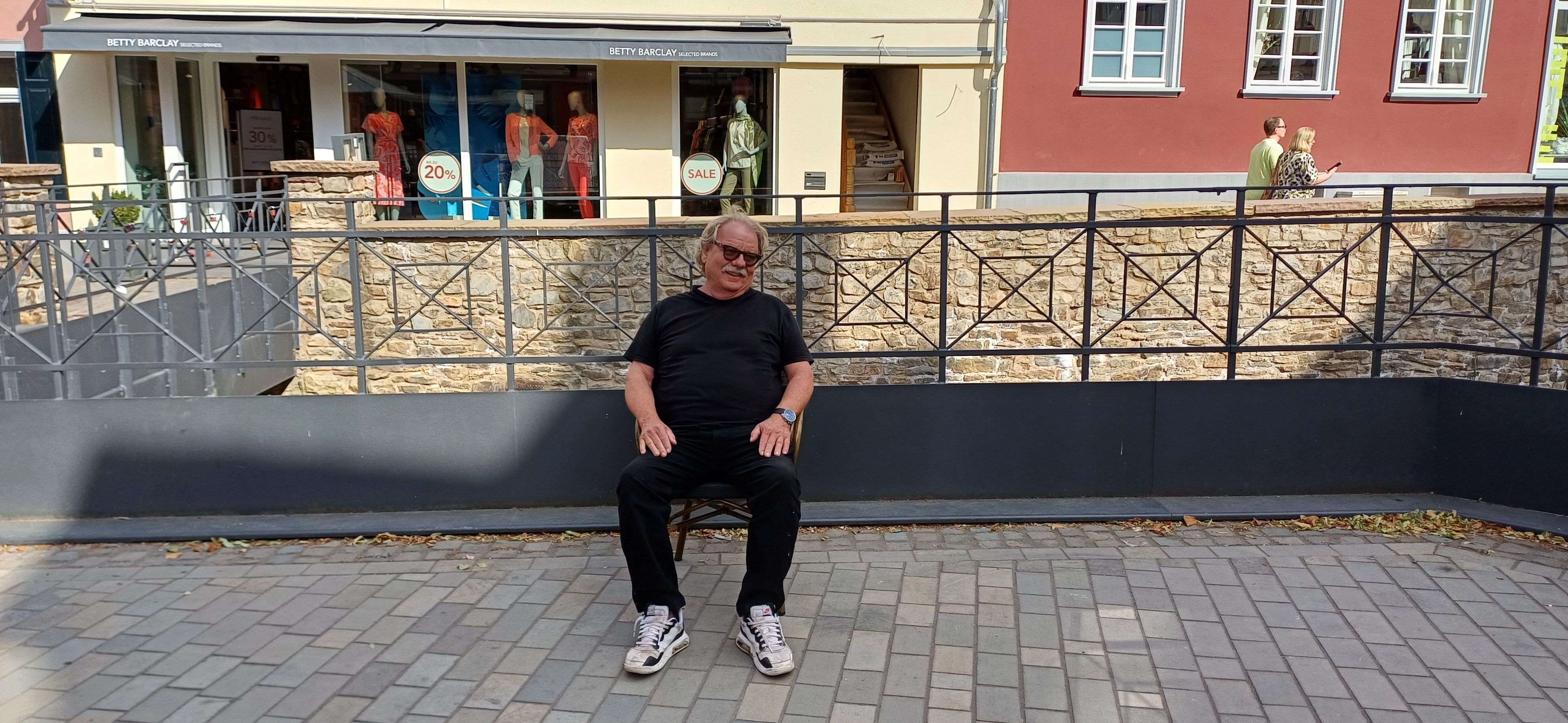 Günter Portz sitzt auf einem Stuhl auf einer bisher vom Printenhaus genutzten Außengastronomiefläche.