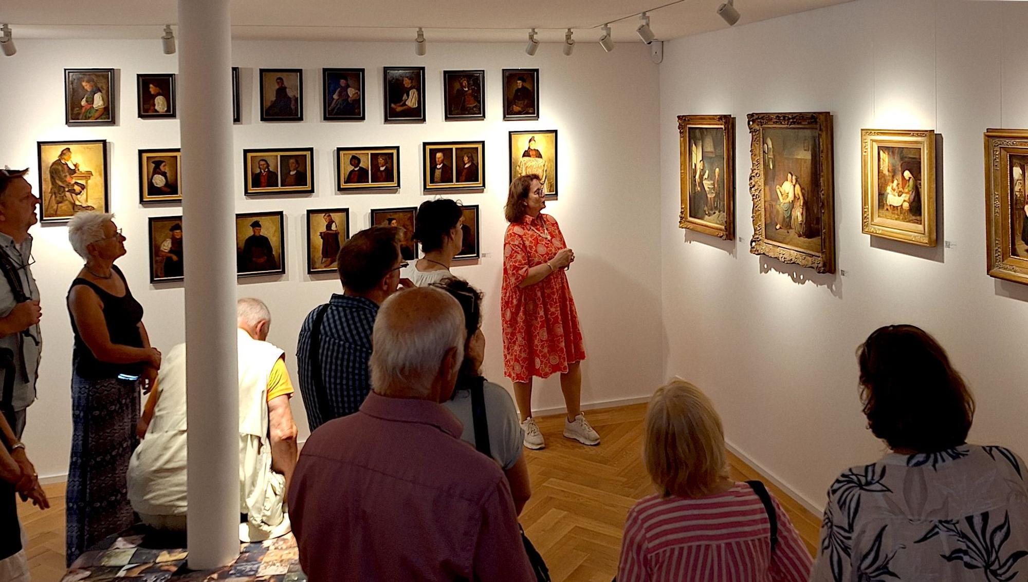 Teilnehmende einer Führung durch das Hubert-Salentin-Museum. An den Wänden hängen zahlreiche Gemälde.