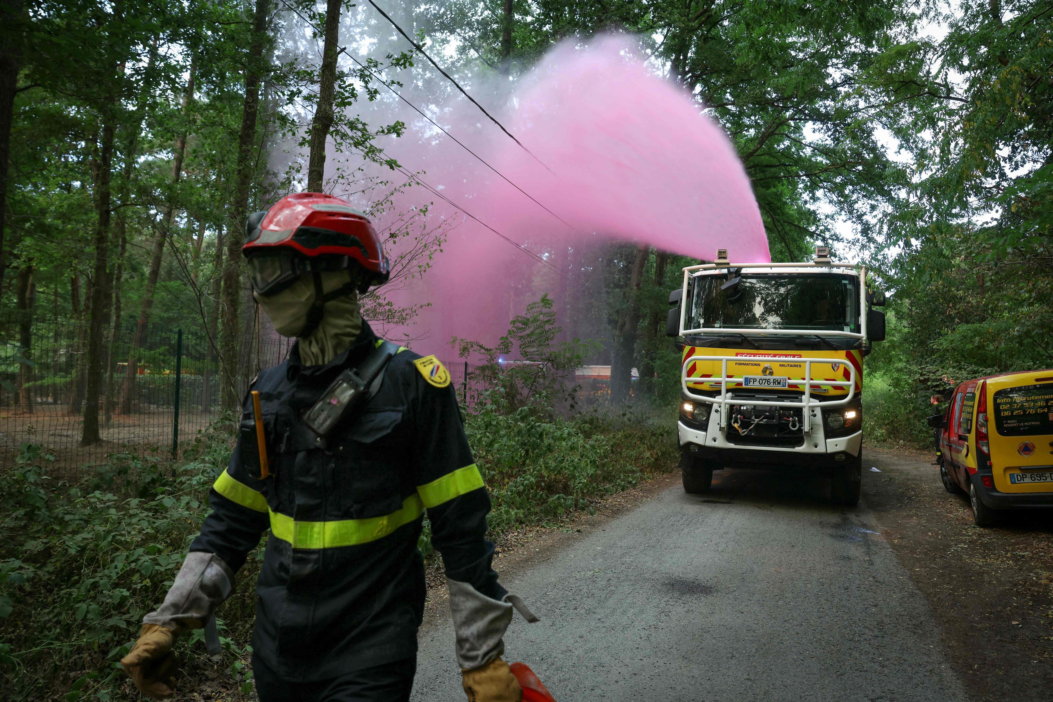 Ein Feuerwehrfahrzeug versprüht Löschmittel im Wald von Fontainebleau nahe Noisy-sur-École in der französischen Region Île-de-France.