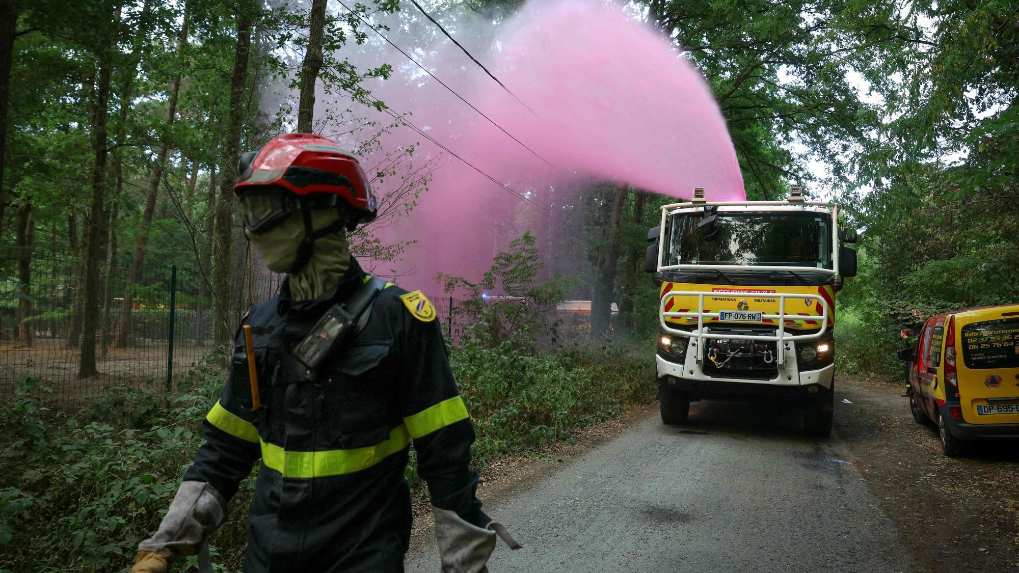 Ein Feuerwehrfahrzeug versprüht Löschmittel im Wald von Fontainebleau nahe Noisy-sur-École in der französischen Region Île-de-France.