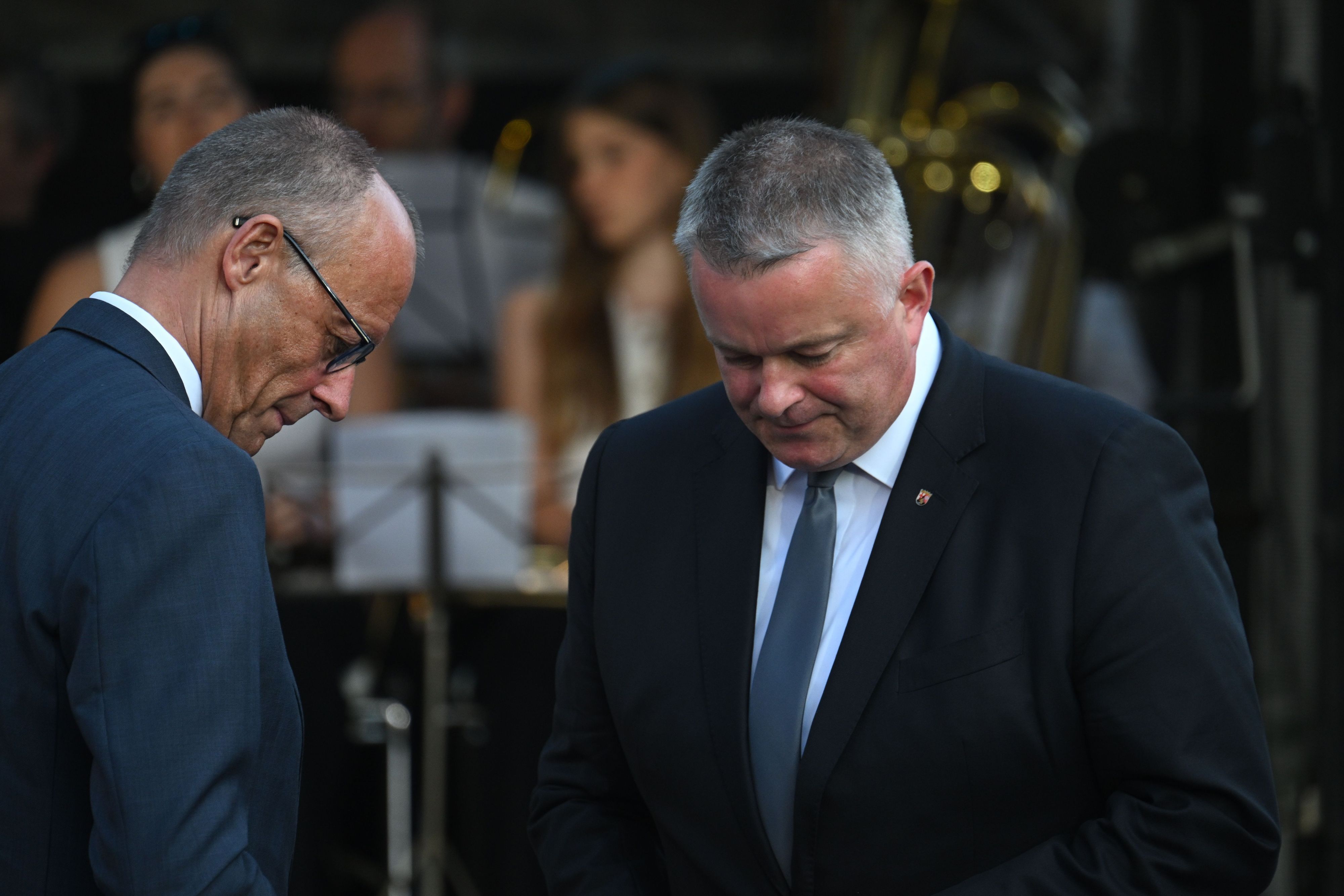 Gordon Schnieder (CDU, r), Ministerpräsident von Rheinland-Pfalz, und Bundeskanzler Friedrich Merz (CDU) stehen am Rande der zentralen Gedenkveranstaltung zum fünften Jahrestag der Flutkatastrophe im Ahrtal auf dem Marktplatz nebeneinander.