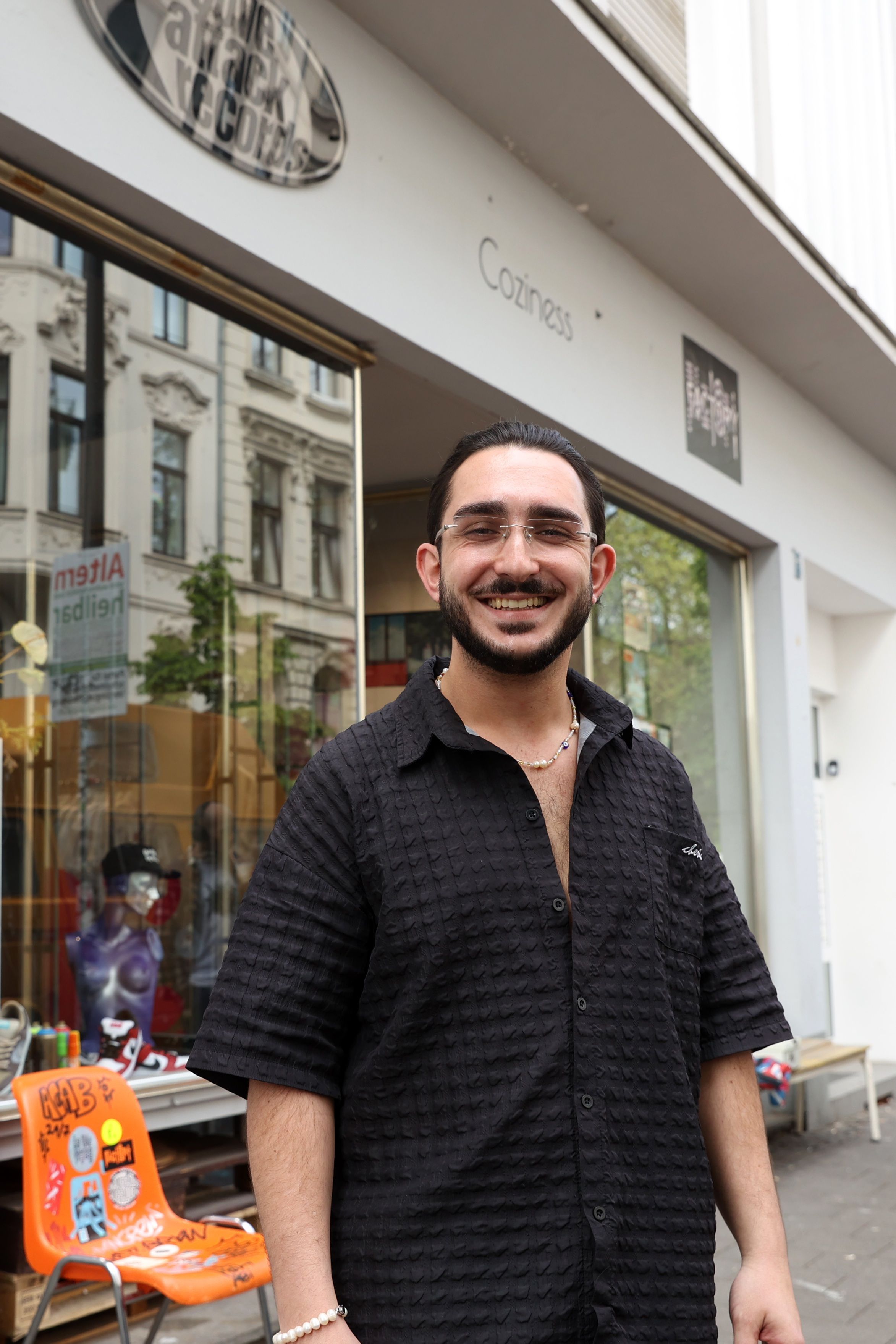 Sinan Senyurt vor dem Sneakerladen Coziness in der Maastrichter Straße. Hier organisiert der Eventmanager auch kulturelle Veranstaltungen.