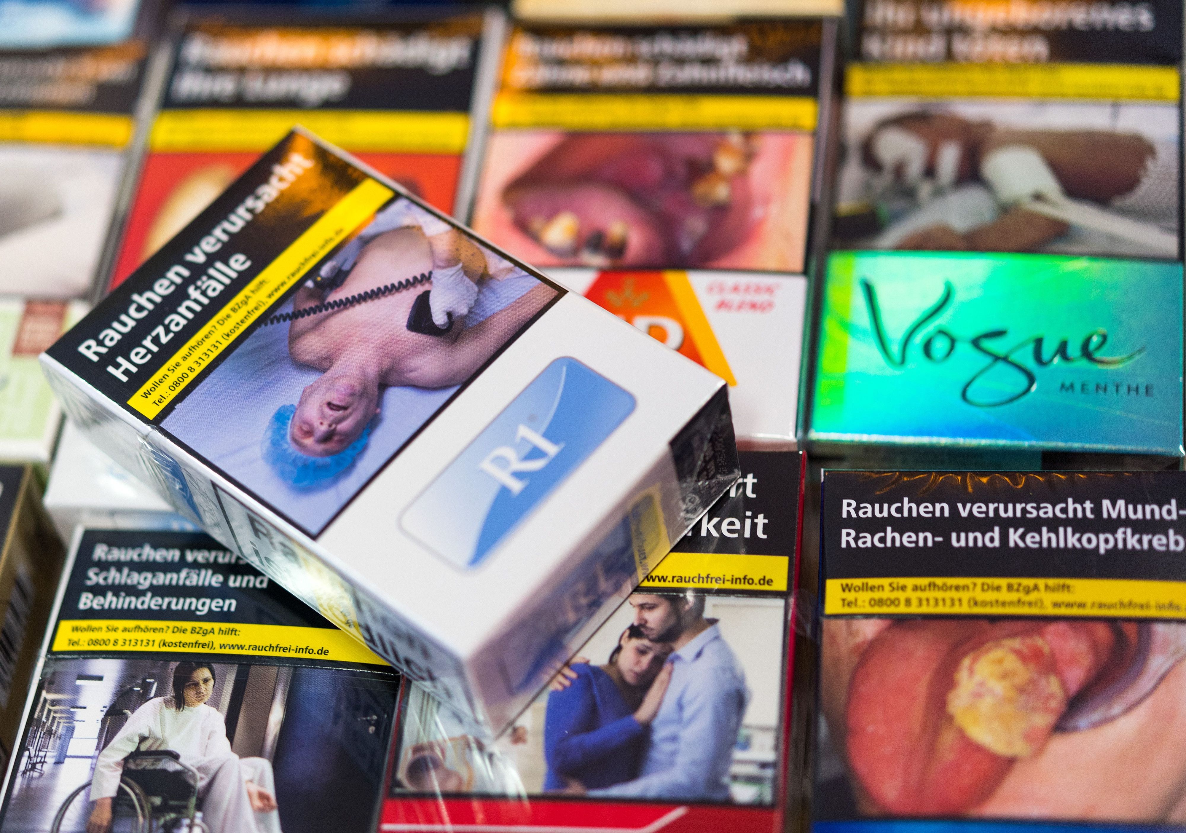 Zigarettenschachteln mit Schockbildern liegen auf einem Tresen in einem Kiosk. (Archivbild)