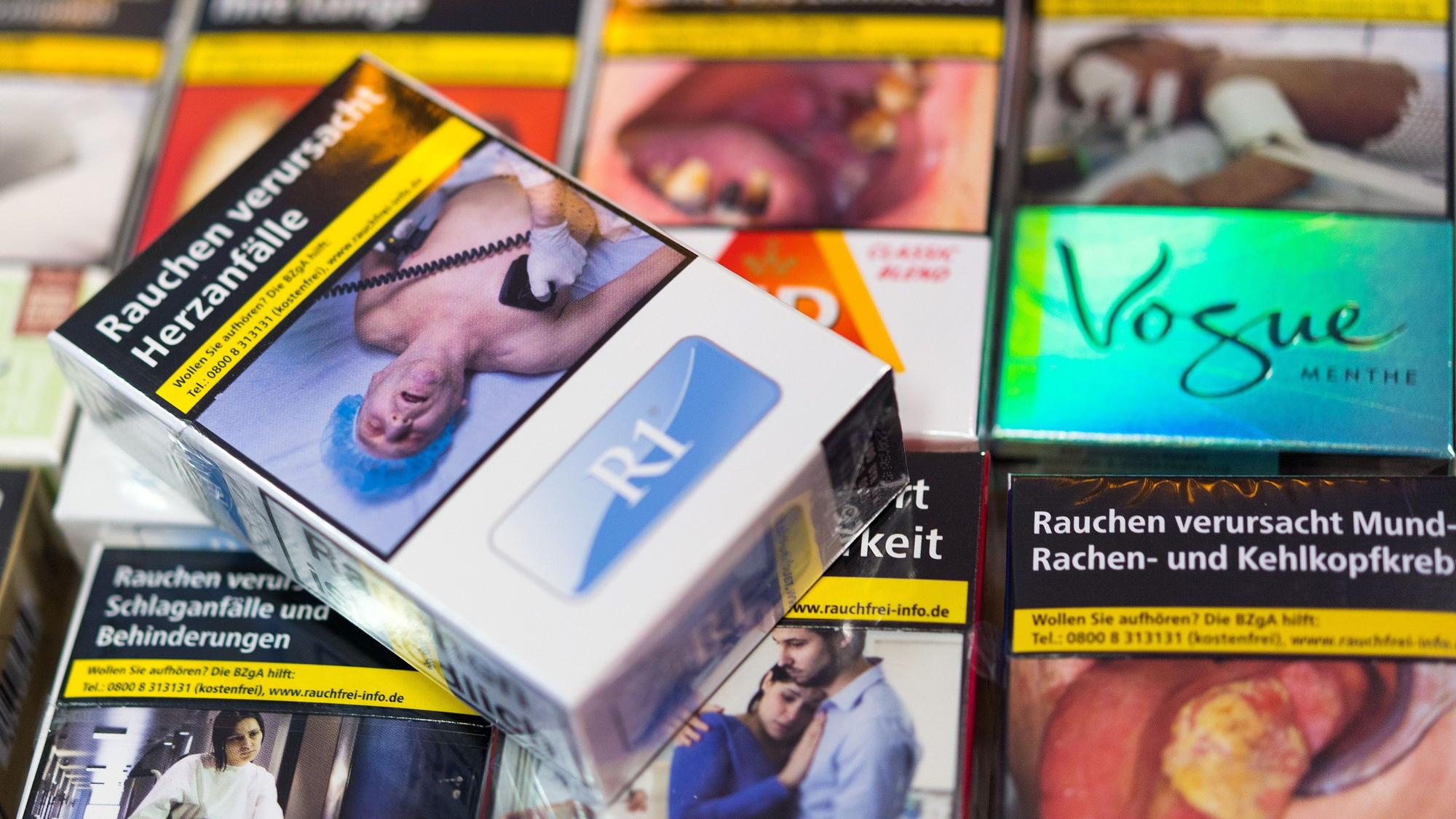 Zigarettenschachteln mit Schockbildern liegen auf einem Tresen in einem Kiosk. (Archivbild)