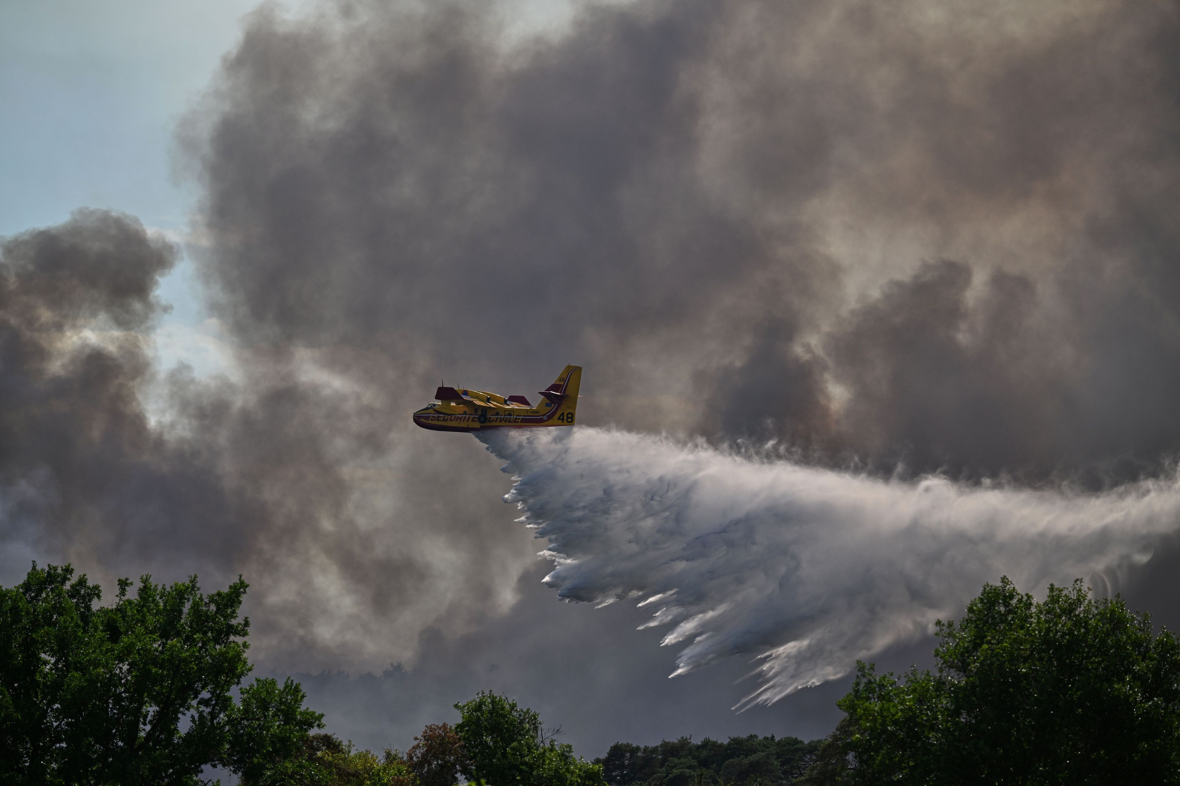 Ein Löschflugzeug vom Typ Canadair wirft Wasser ab, während eines Einsatzes gegen einen Waldbrand bei Fontainebleau.