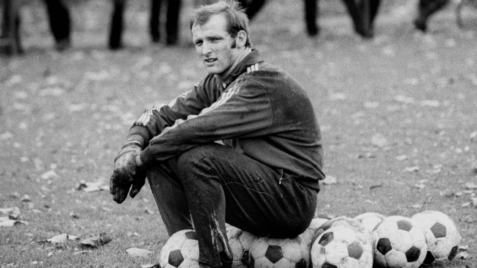 Torwart Manfred Manglitz sitzt am 10. November 1969 beim Training des 1. FC Köln auf Bällen.