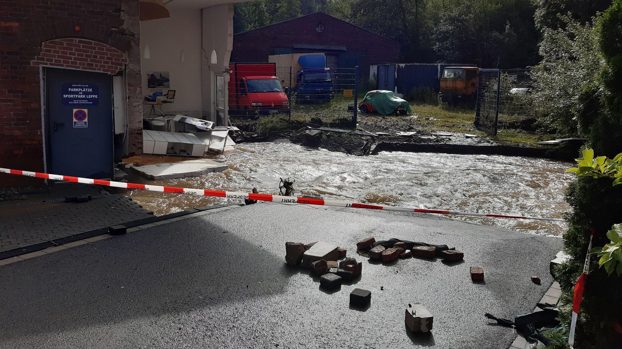 Ein Fluss fließt an einem zerstörten Haus vorbei.