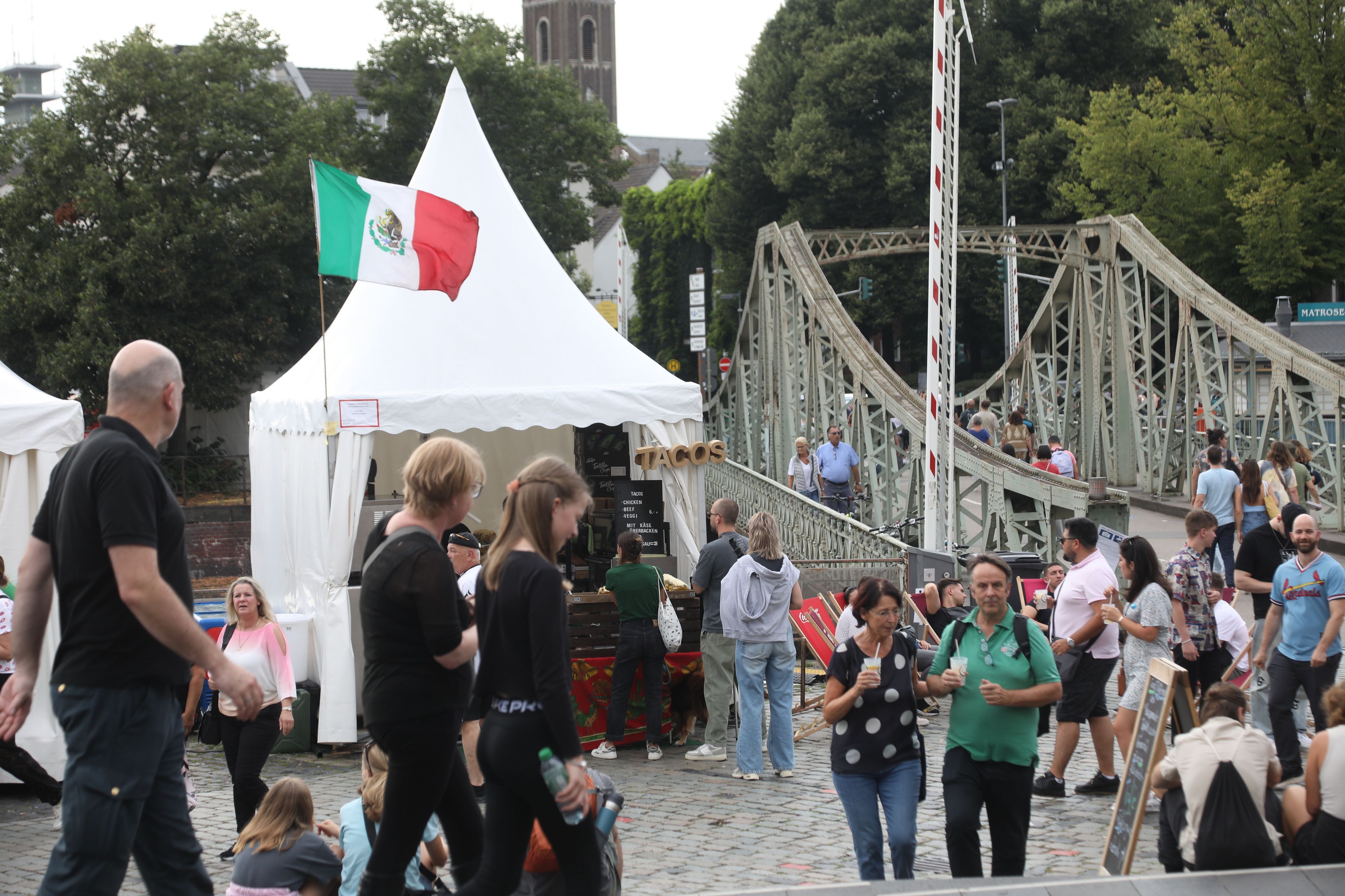 Besucher und Essensstand mit mexikanischer Flagge auf dem Vorplatz des Schokoladenmuseums