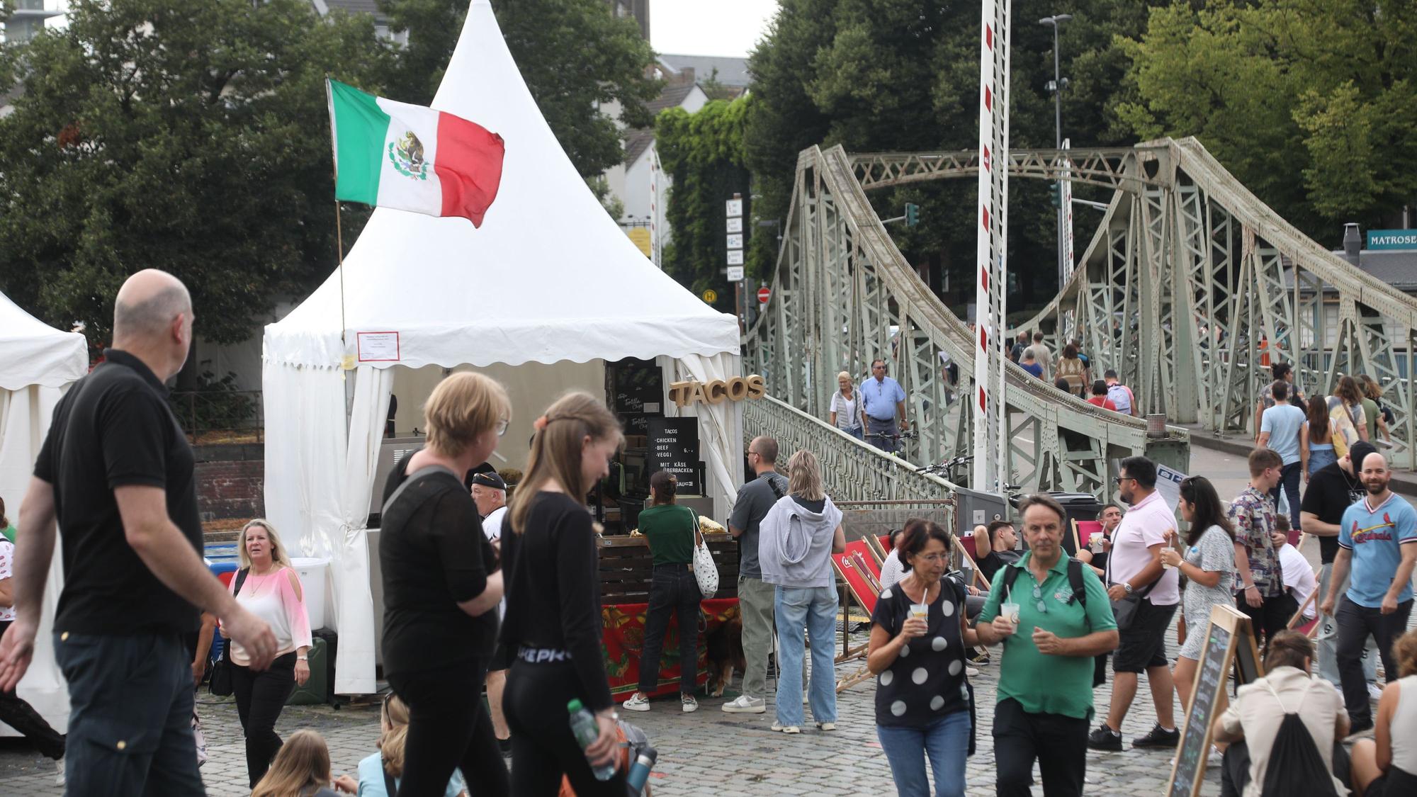 Besucher und Essensstand mit mexikanischer Flagge auf dem Vorplatz des Schokoladenmuseums