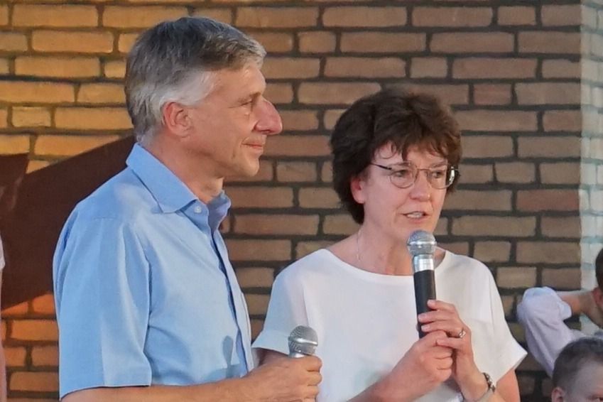 Ein Mann und eine Frau stehen nebeneinander und sprechen in ein Mikrofon.