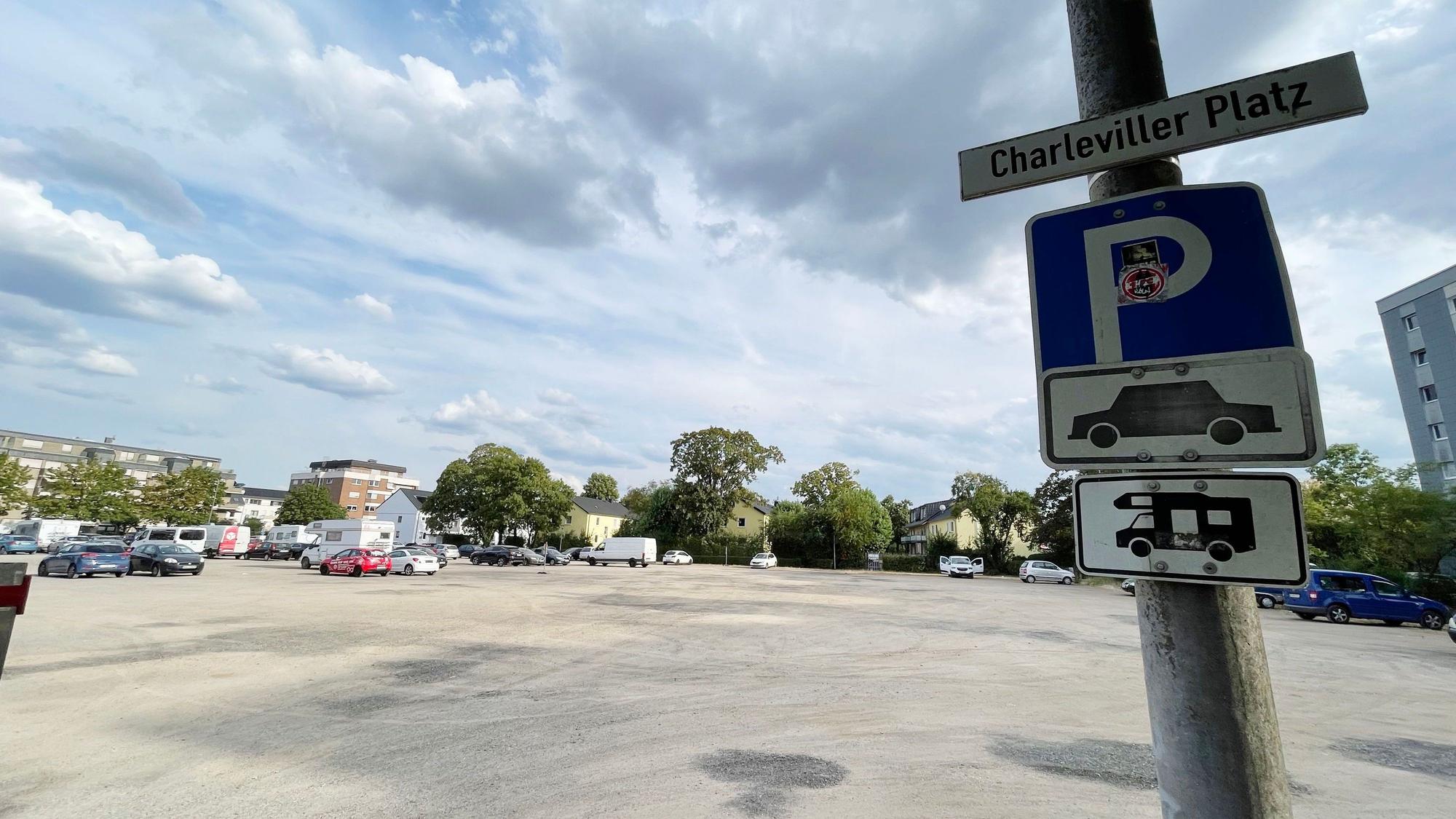 Am Rande des Geländes hängen Schilder mit Auto- und Wohnmobilpiktogrammen.