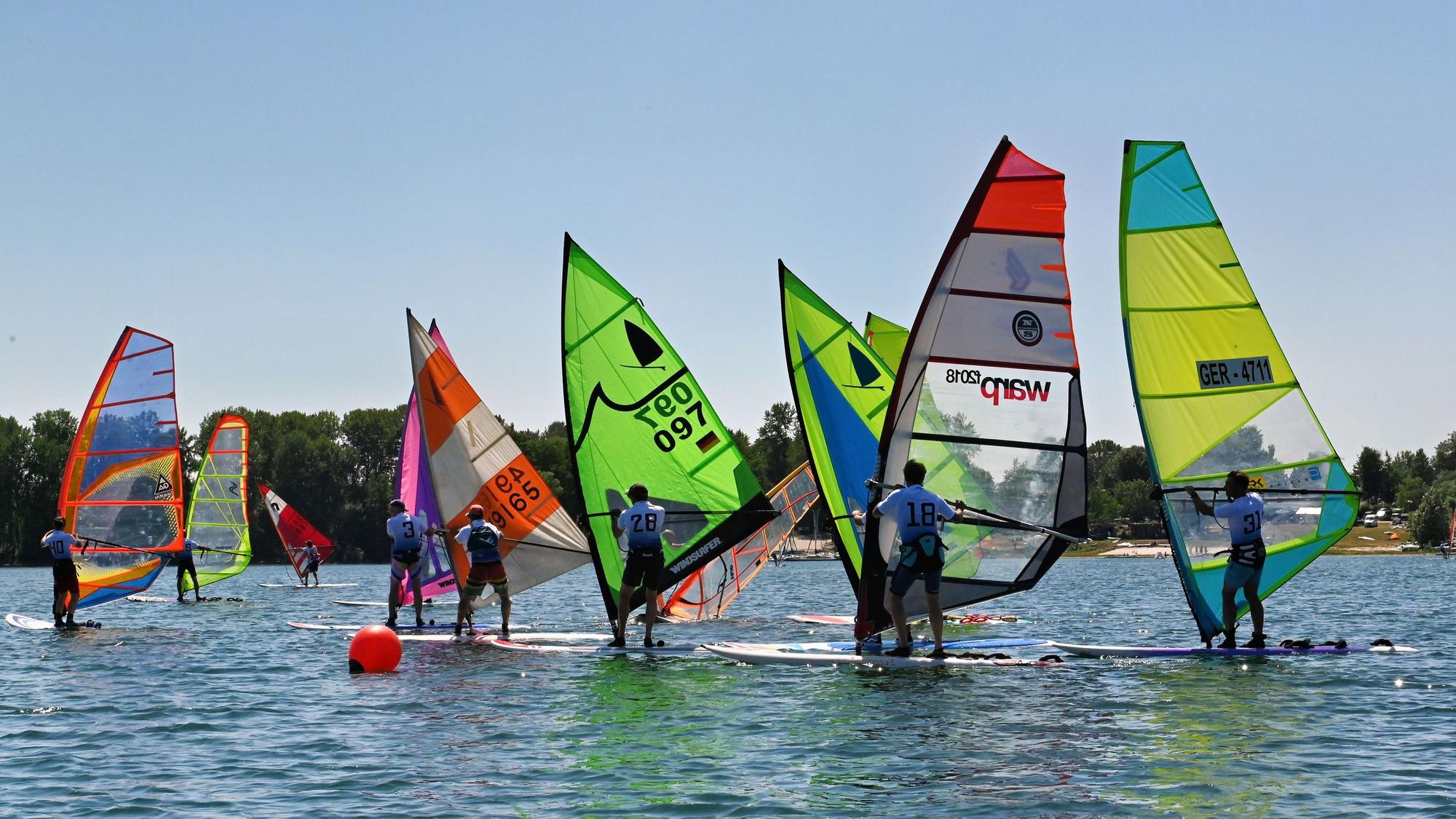 Das Bild zeigt einige Windsurfer auf dem Zülpicher See.