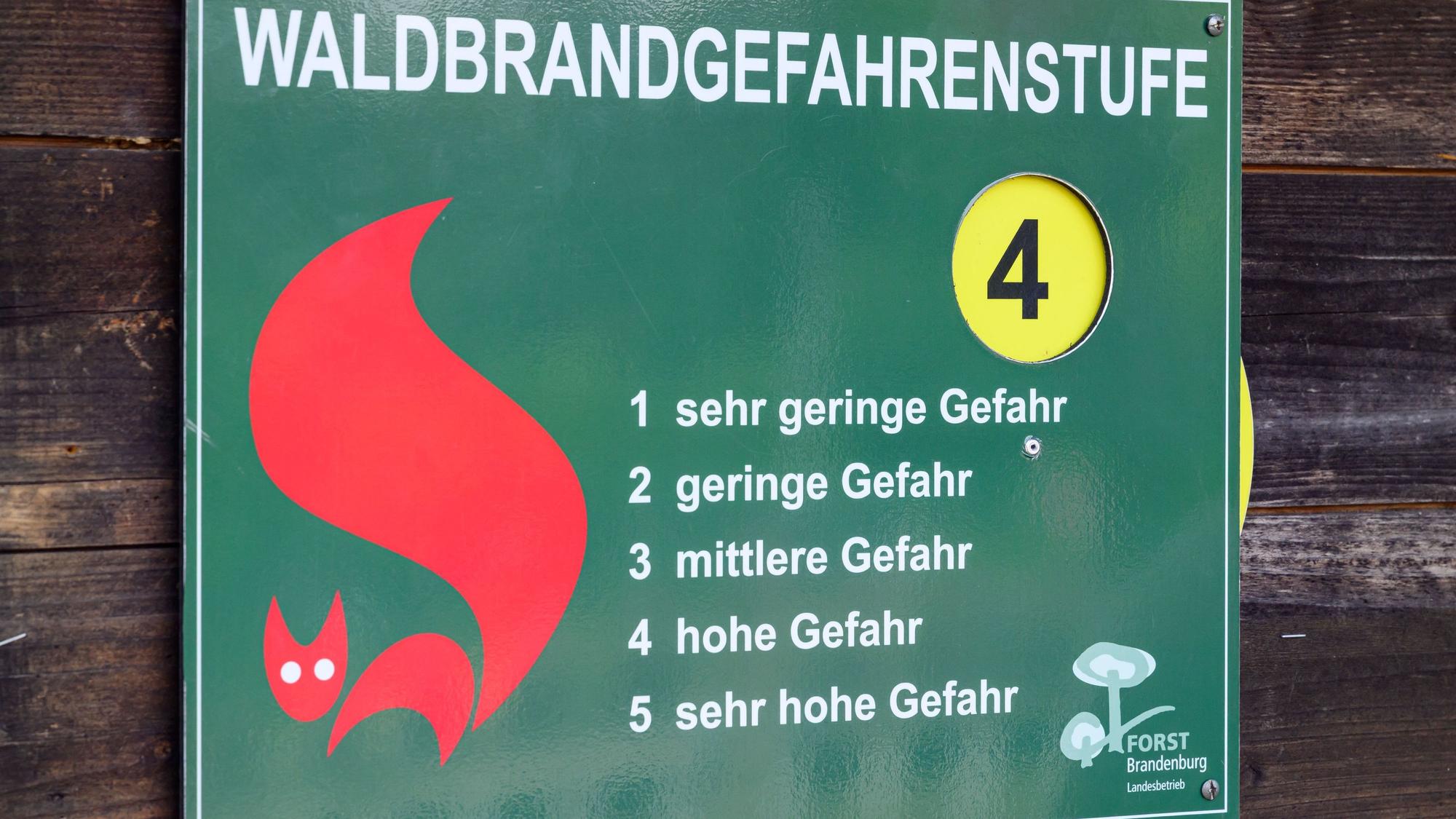 Ein Schild vom Landesbetrieb Forst Brandenburg mit den Waldbrandgefahrenstufen steht auf Stufe 4 – hohe Gefahr. Diese Stufe gilt zurzeit auch in Köln.