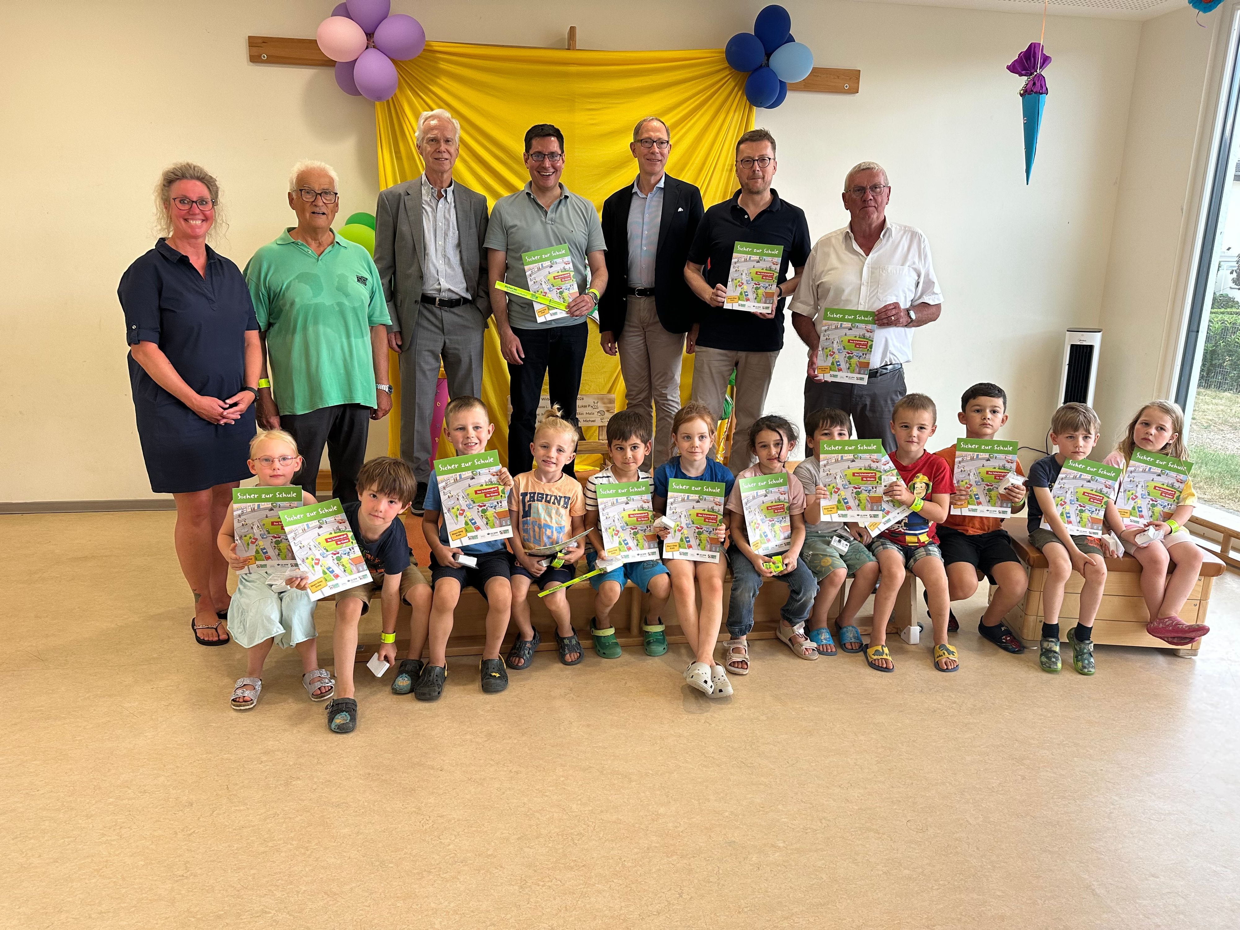 Die kommenden Schulkinder zeigen stolz ihre Lernhefte zusammen mit Vertretern aus der Politik, Verwaltung und der Verkehrswacht.