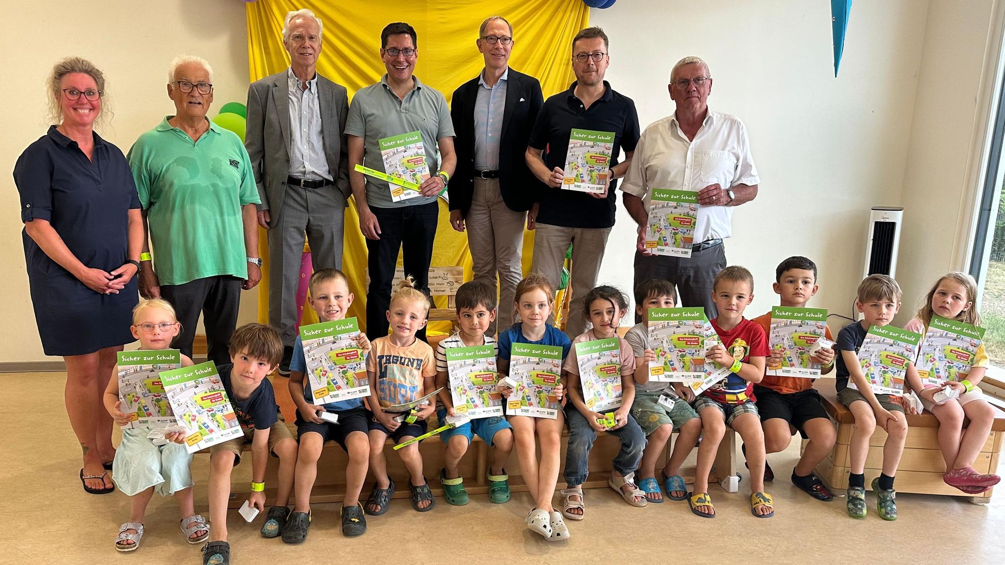 Die kommenden Schulkinder zeigen stolz ihre Lernhefte zusammen mit Vertretern aus der Politik, Verwaltung und der Verkehrswacht.
