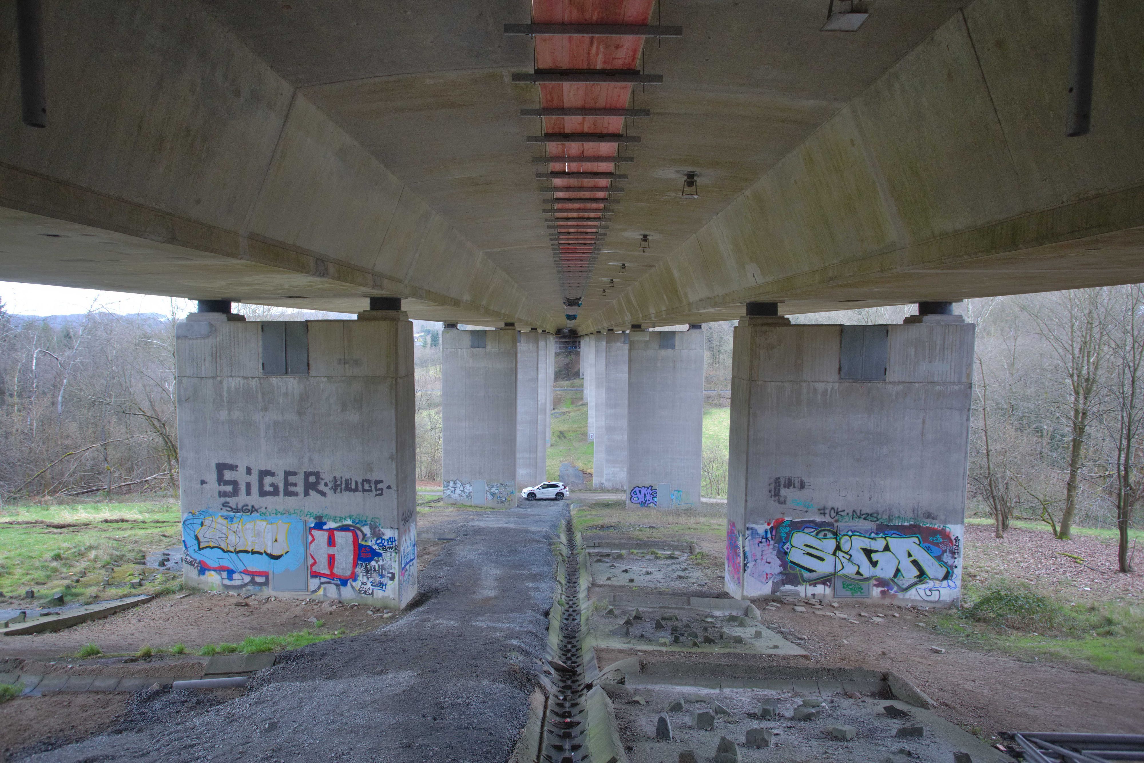 Zu sehen ist eine Autobahnbrücke von unten.
