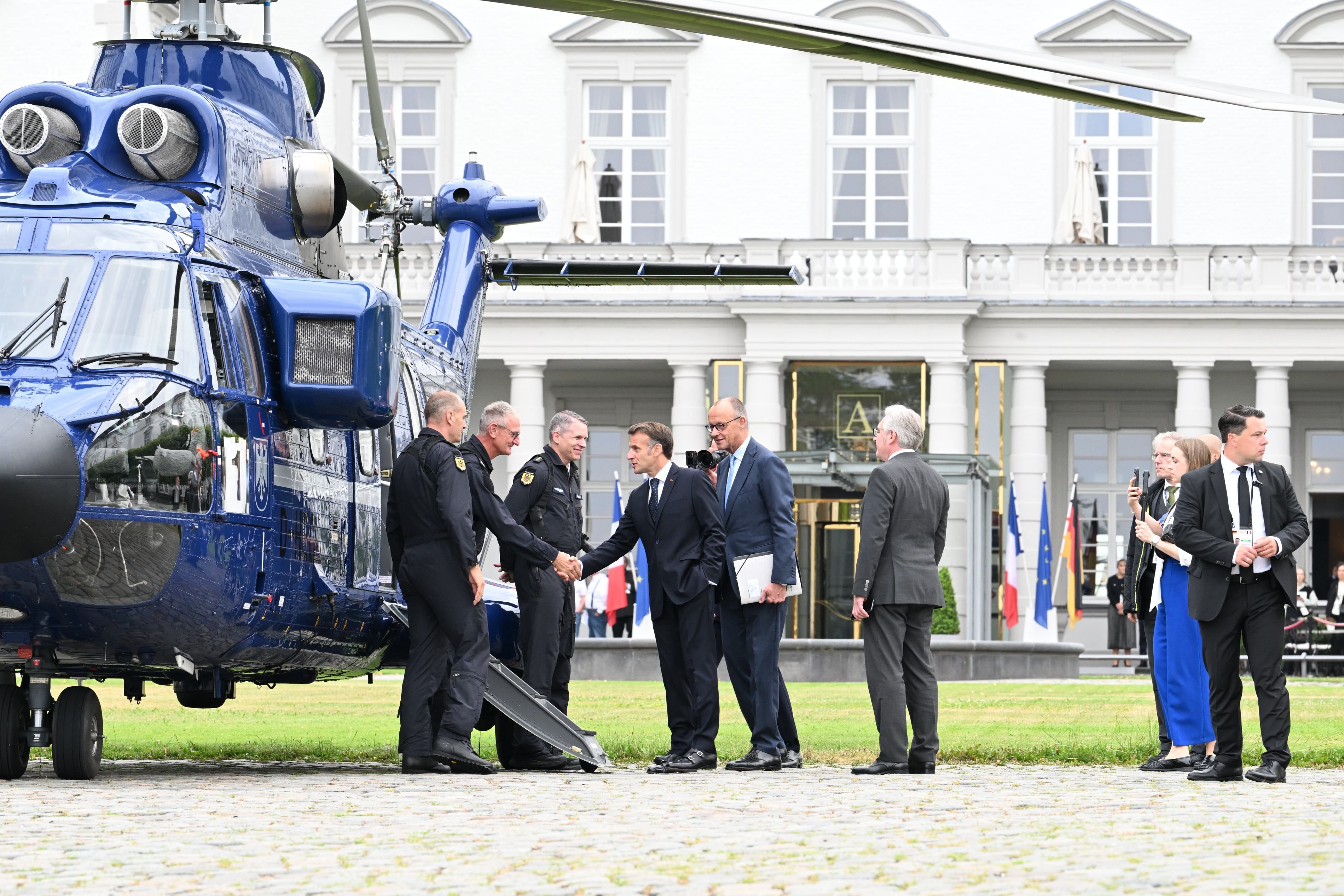 Friedrich Merz Merz und Emmanuel Macron stehen vor dem Hubschrauber.