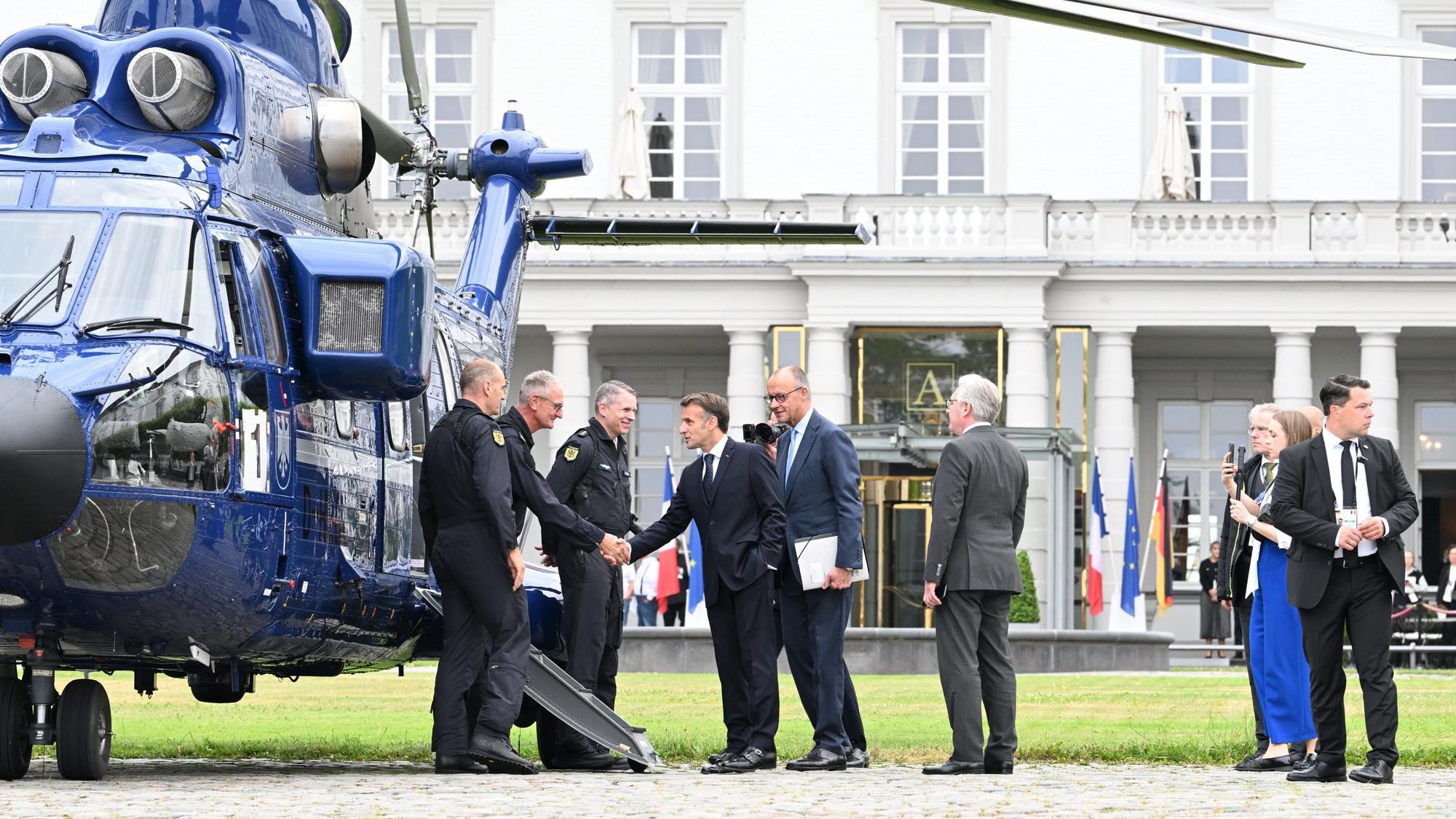Friedrich Merz Merz und Emmanuel Macron stehen vor dem Hubschrauber.