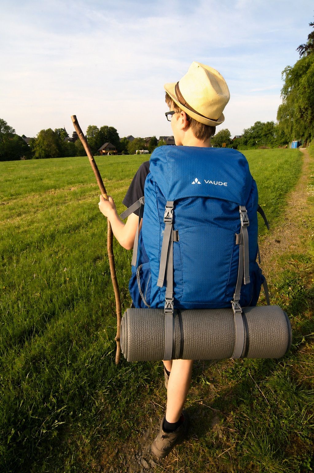 Eine blaue Isomatte hängt an einem grauen Rucksack.