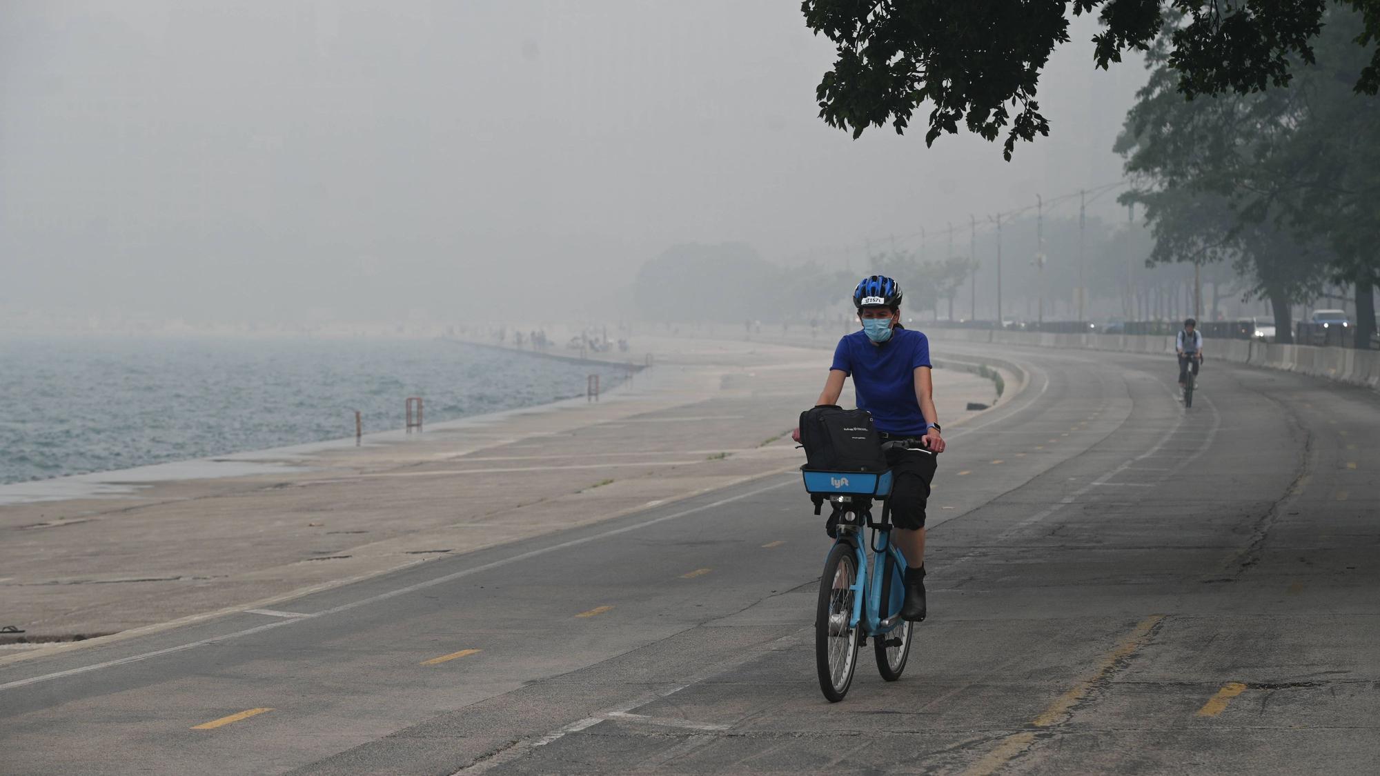 Eine Radfahrerin trägt in Chicago eine Maske, um sich vor der schlechten Luft zu schützen.