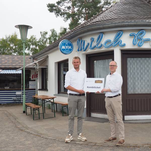 Roland Barth (l.) und Dr. Carsten Vorwig stehen im Museum vor der Milchbar und halten gemeinsam ein übergroßes Kombiticket.