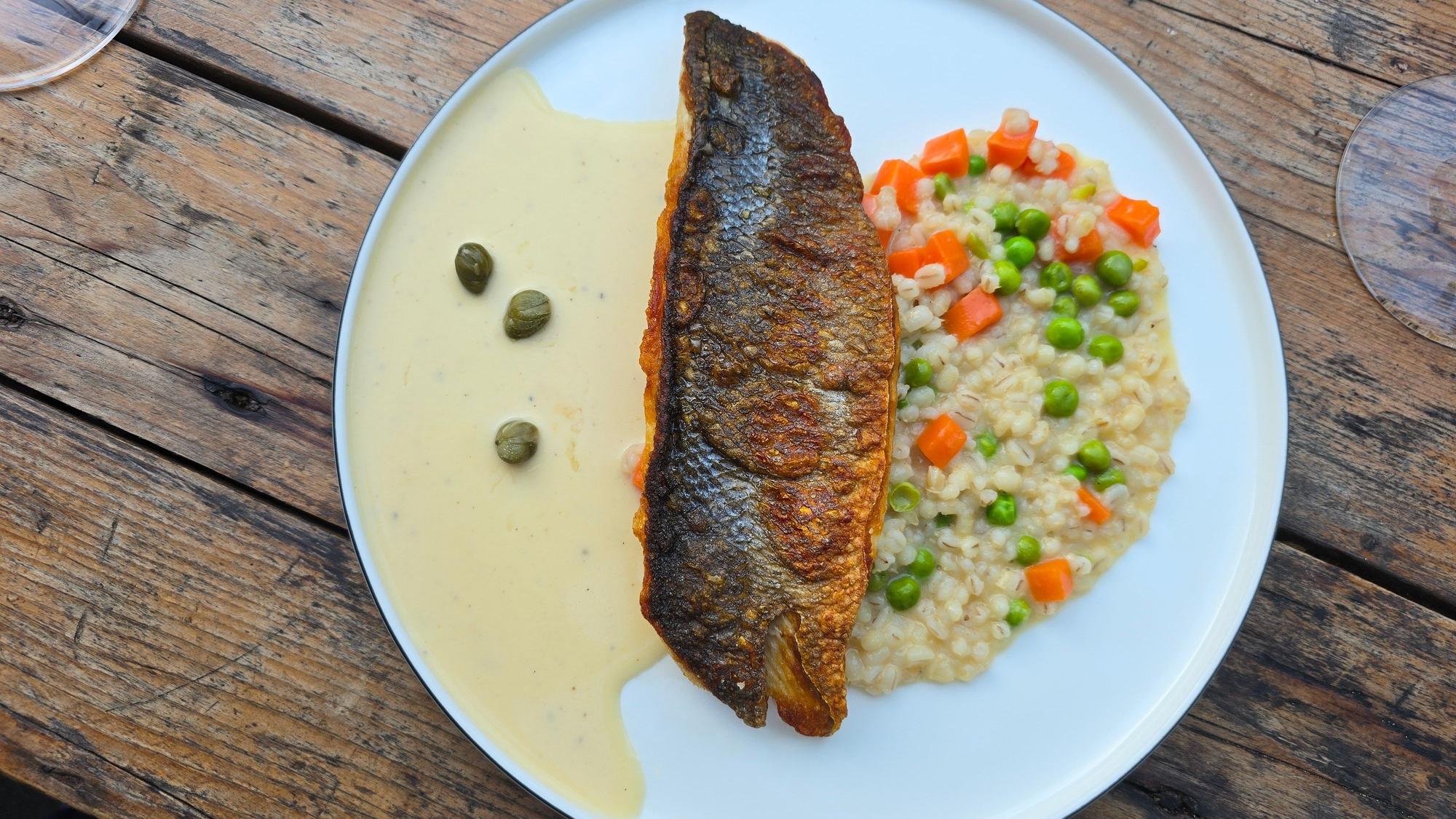 Wolfsbarsch mit Graupenrisotto, Erbsengemüse, Kapernbuttersauce