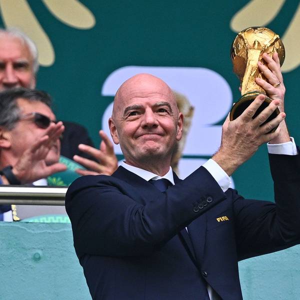 Gianni Infantino hält auf der Tribübne einen Pokal hoch.