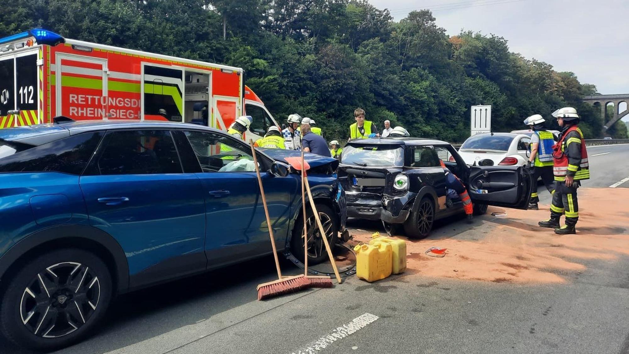 Beschädigte Autos und Einsatzkräfte an einer Unfallstelle.