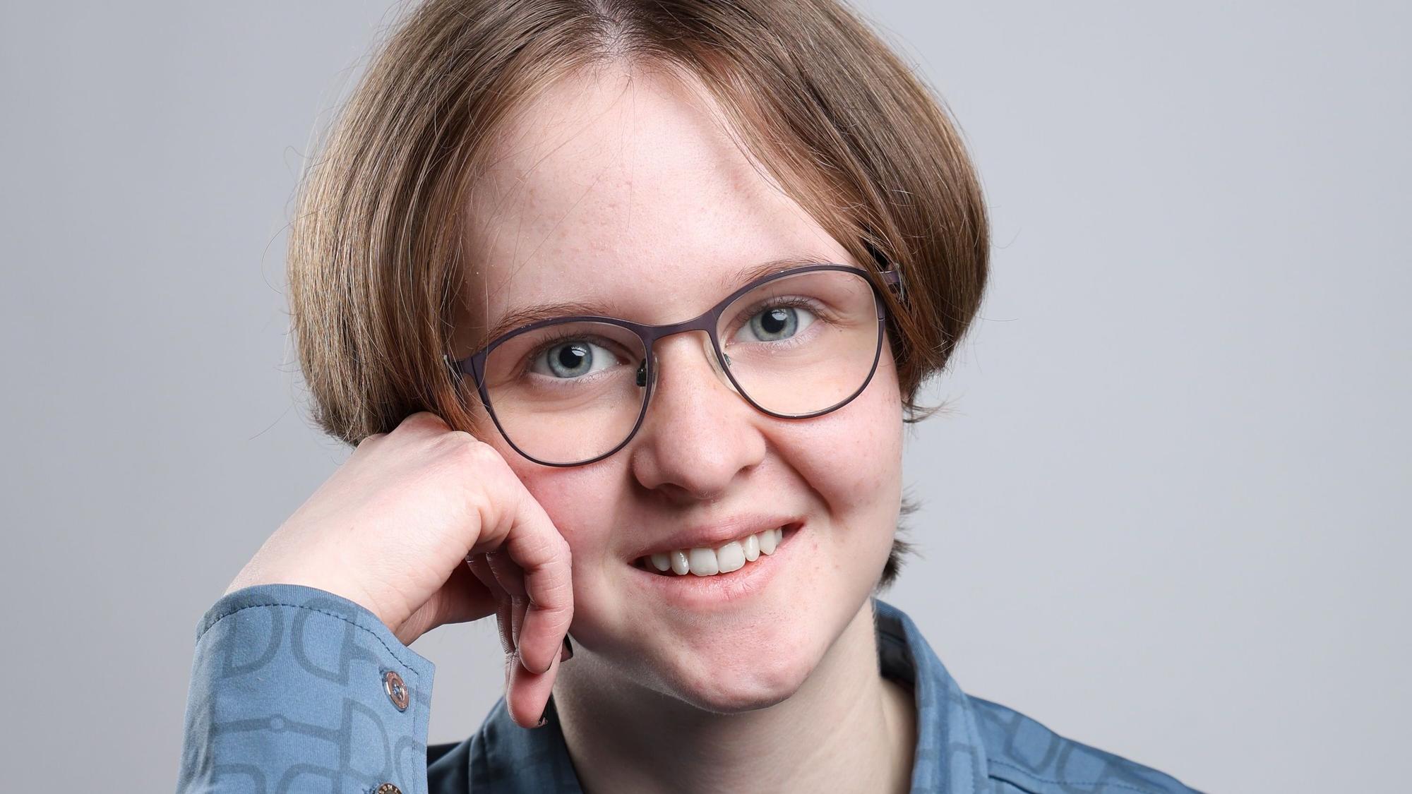 Maribelle Aßmus posiert für ein Portrait, stützt den Kopf auf eine Hand.