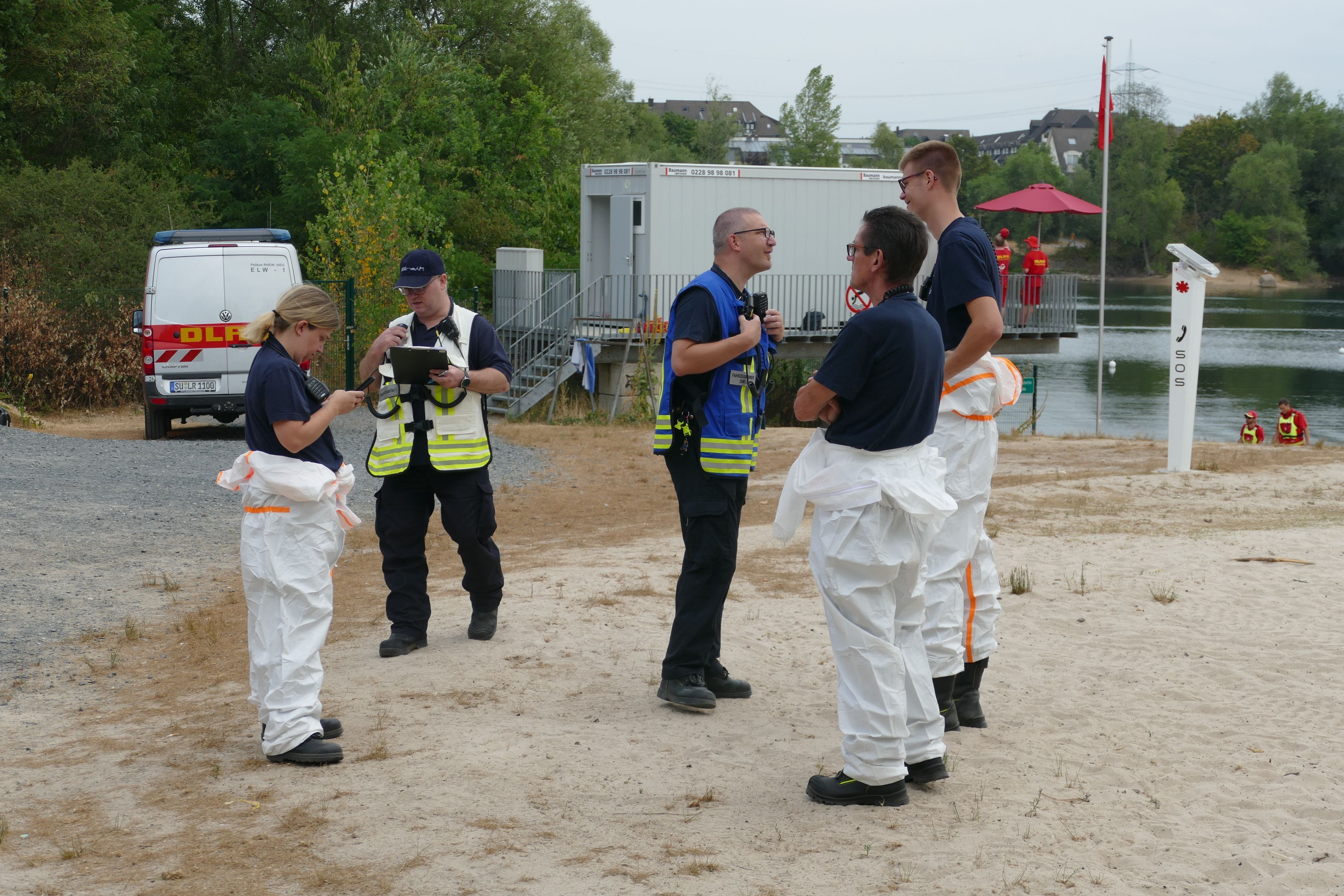 Einsatzkräfte der Feuerwehr und DLRG an einem Badesee.