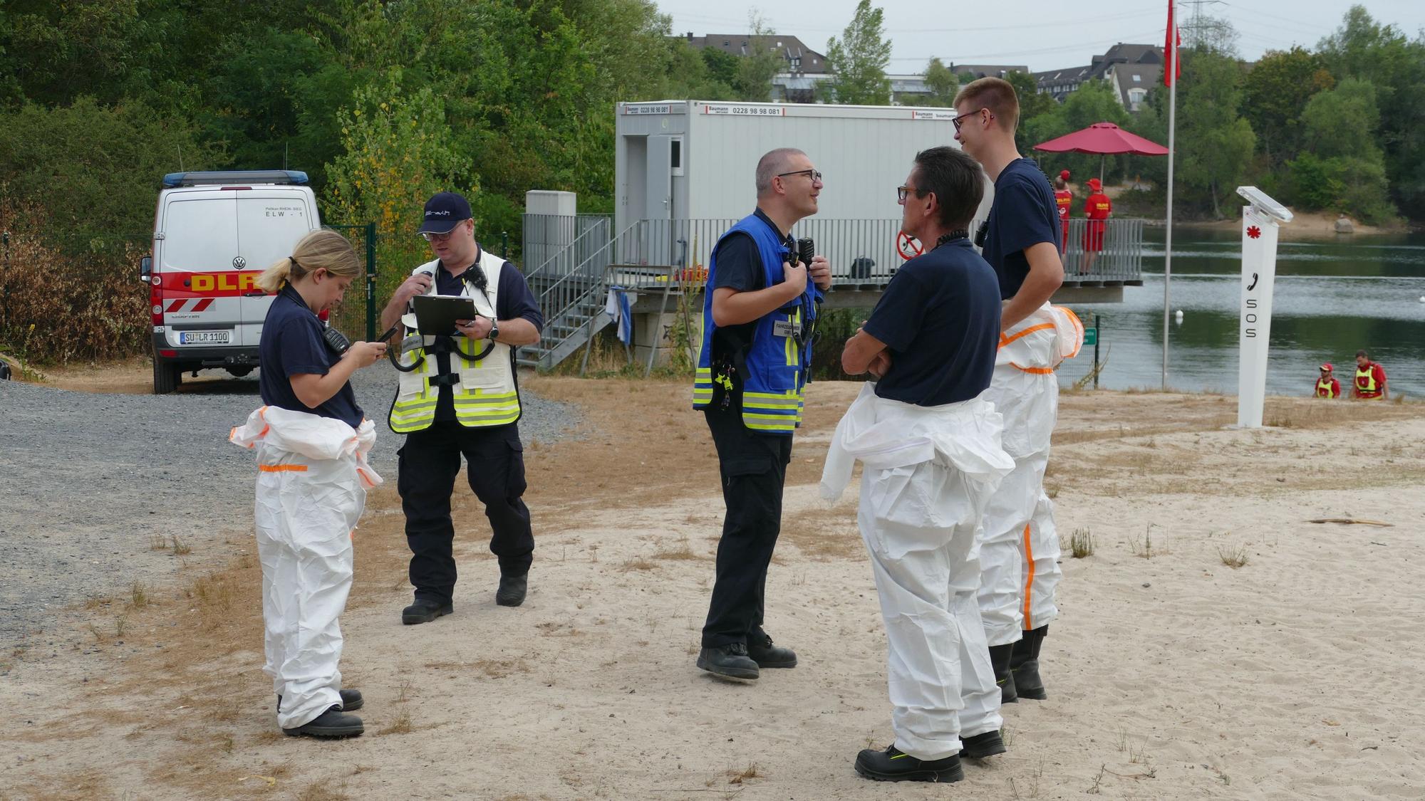 Einsatzkräfte der Feuerwehr und DLRG an einem Badesee.