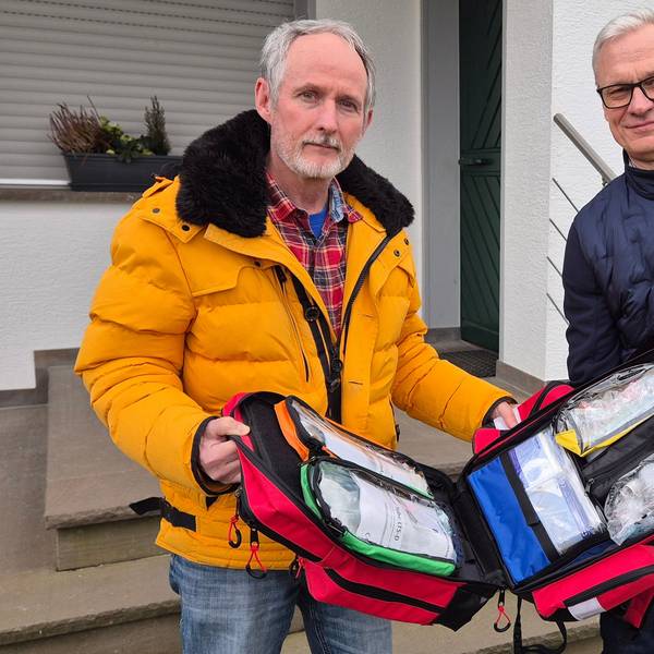 Axel Wild, Vorsitzender der Reservistenkameradschaft Lindlar und Oberstleutnant der Reserve, überreicht Georg Ludwig einen Notfallrucksack.