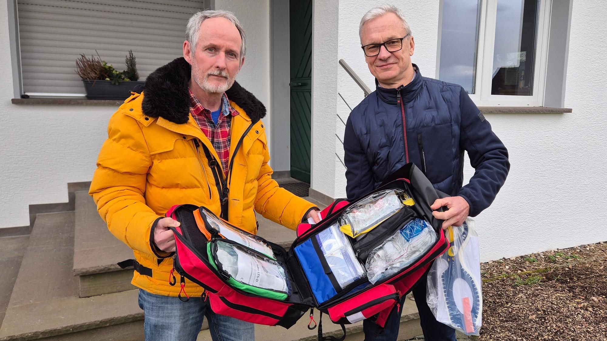 Axel Wild, Vorsitzender der Reservistenkameradschaft Lindlar und Oberstleutnant der Reserve, überreicht Georg Ludwig einen Notfallrucksack.