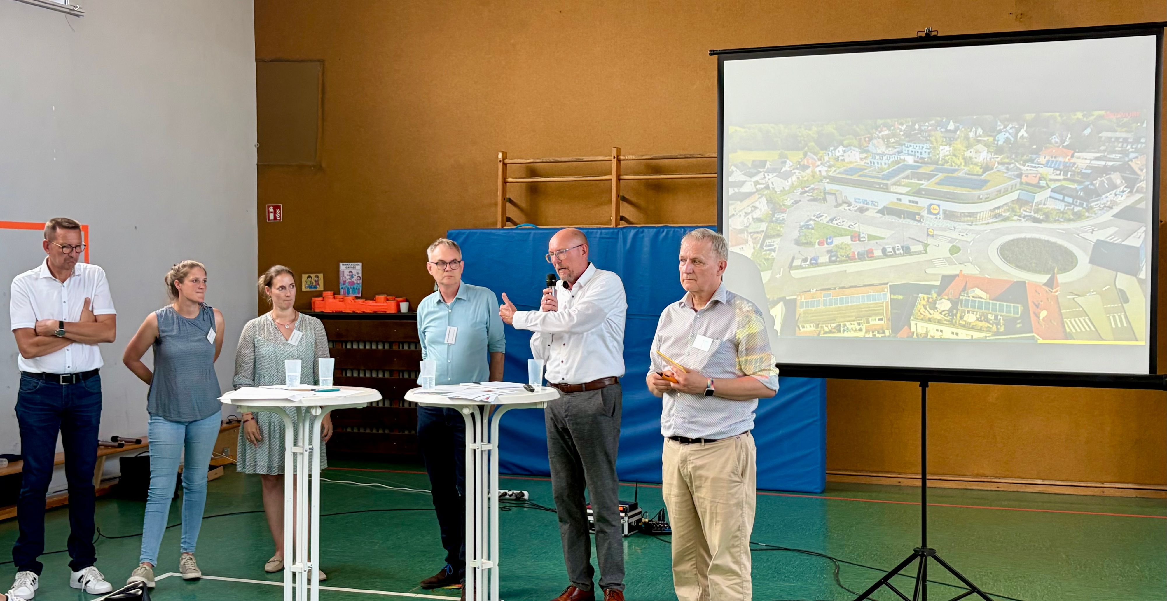 Bürgermeister Dirk Runge, Stadtplanerin Diana Papierz, Nadine Flüchter, Planer Hubertus Zimmermann und Jörg Beensen von Lidl mit dem Moderator Michael Lobeck