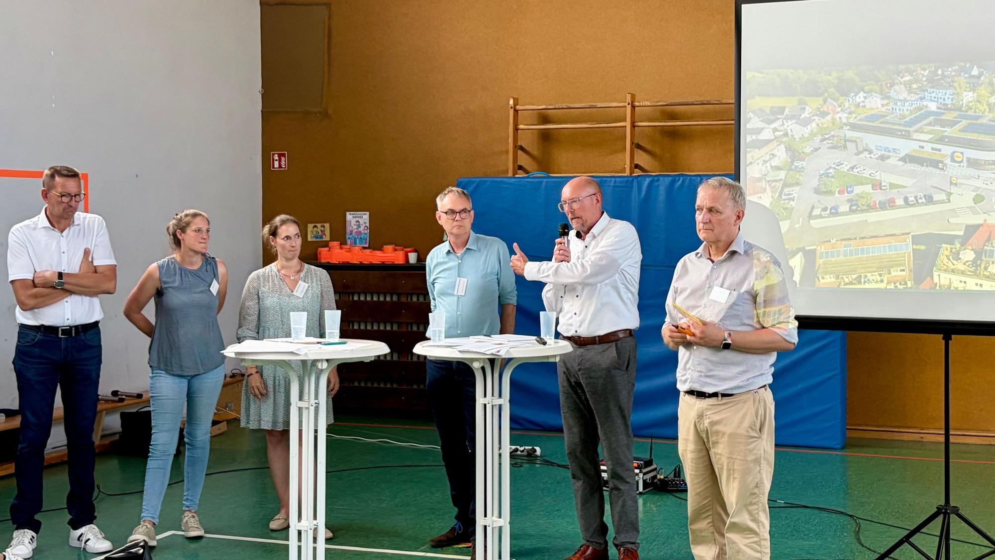 Bürgermeister Dirk Runge, Stadtplanerin Diana Papierz, Nadine Flüchter, Planer Hubertus Zimmermann und Jörg Beensen von Lidl mit dem Moderator Michael Lobeck