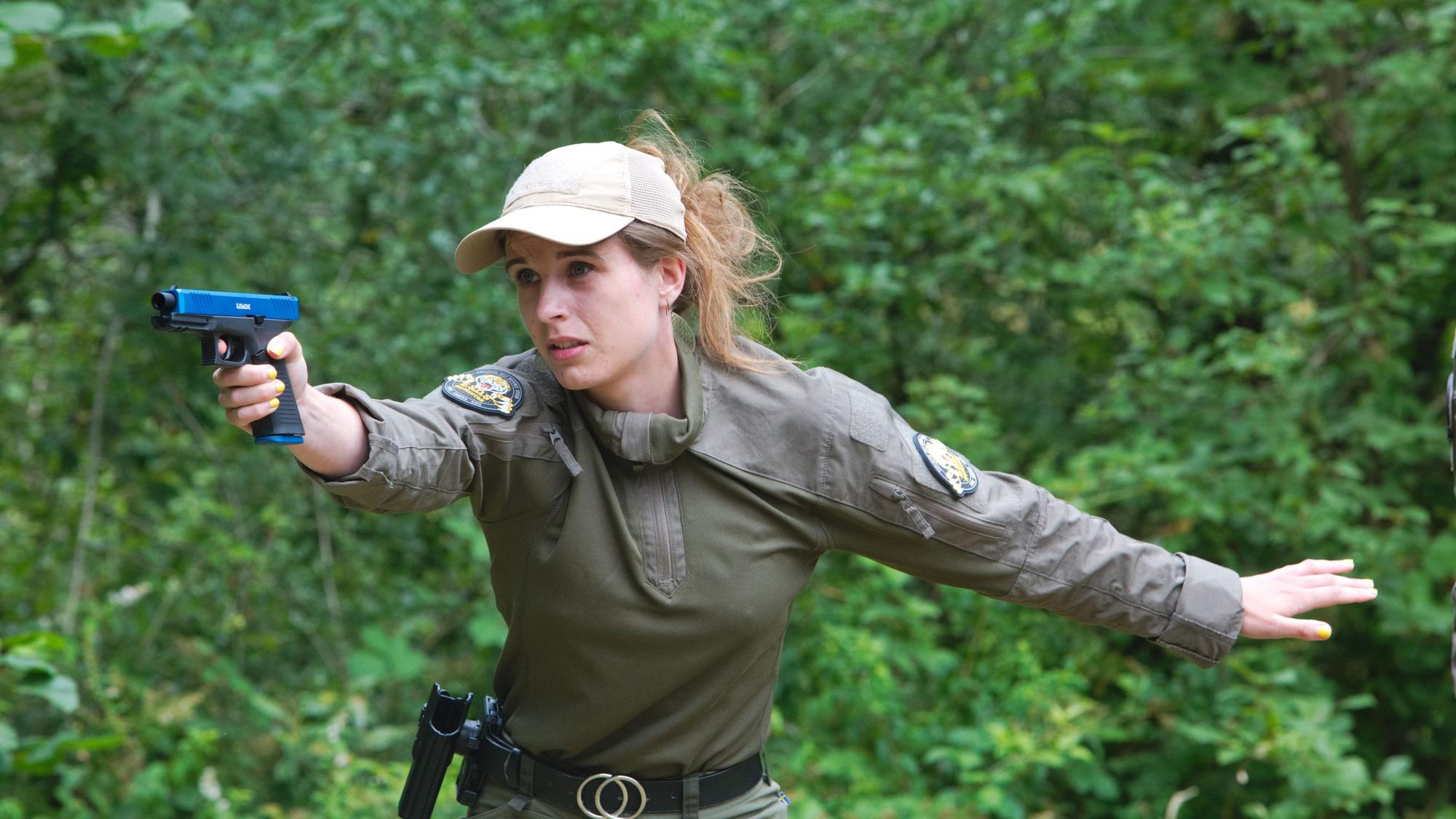 Eine Polizistin mit Waffe in der Hand bei einem Schusstraining.
