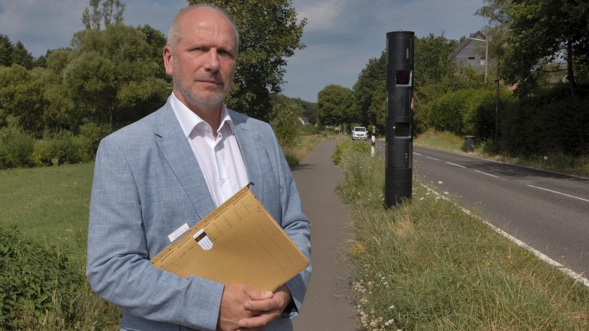 Das Foto zeigt Rechtsanwalt Volker Steffen aus Nümbrecht-Niederbröl vor dem fest installierten
Blitzer an der Landesstraße 339.