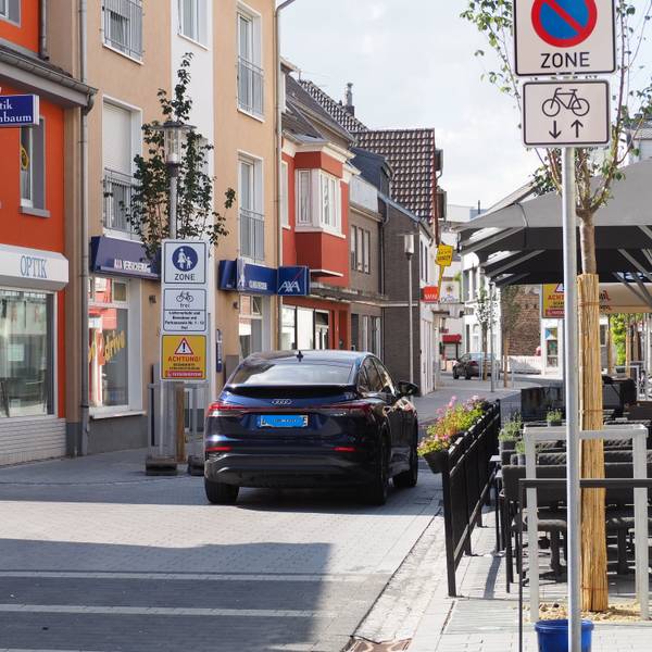 Ein Auto fährt auf der Münsterstraße. Links ist das Schild zu sehen, das auf die Fußgängerzone hinweist und auf die geänderte Verkehrsregelung.