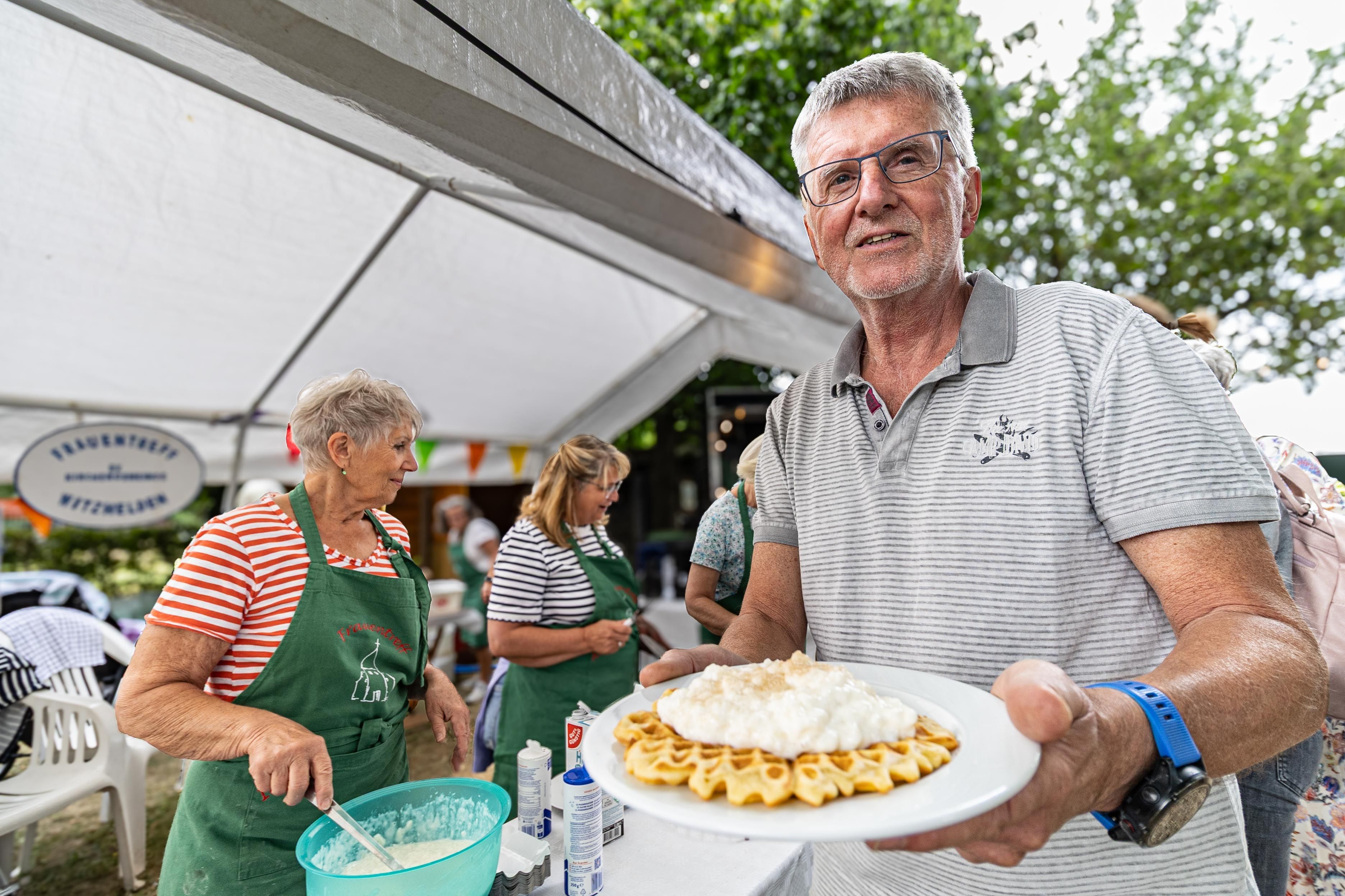 Ein Mann hält einen Teller mit einer Waffel und Reisbrei.